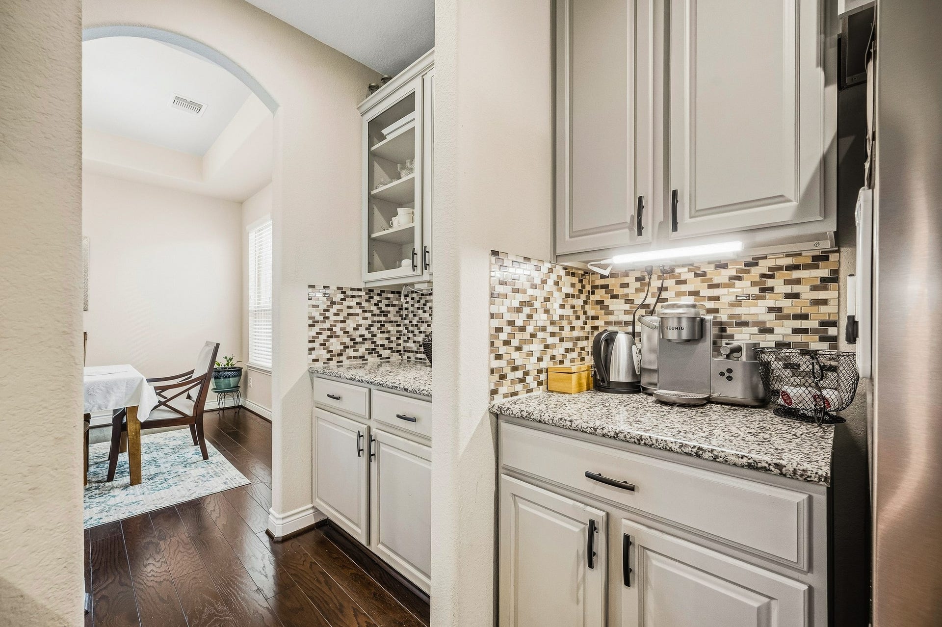 25610 Buckley Bluff Lane, Katy, TX 77494 Experience the charm of an elegant kitchen nook with sleek granite countertops and a stylish mosaic tile backsplash, seamlessly flowing into a bright dining area adorned with rich hardwood flooring.
