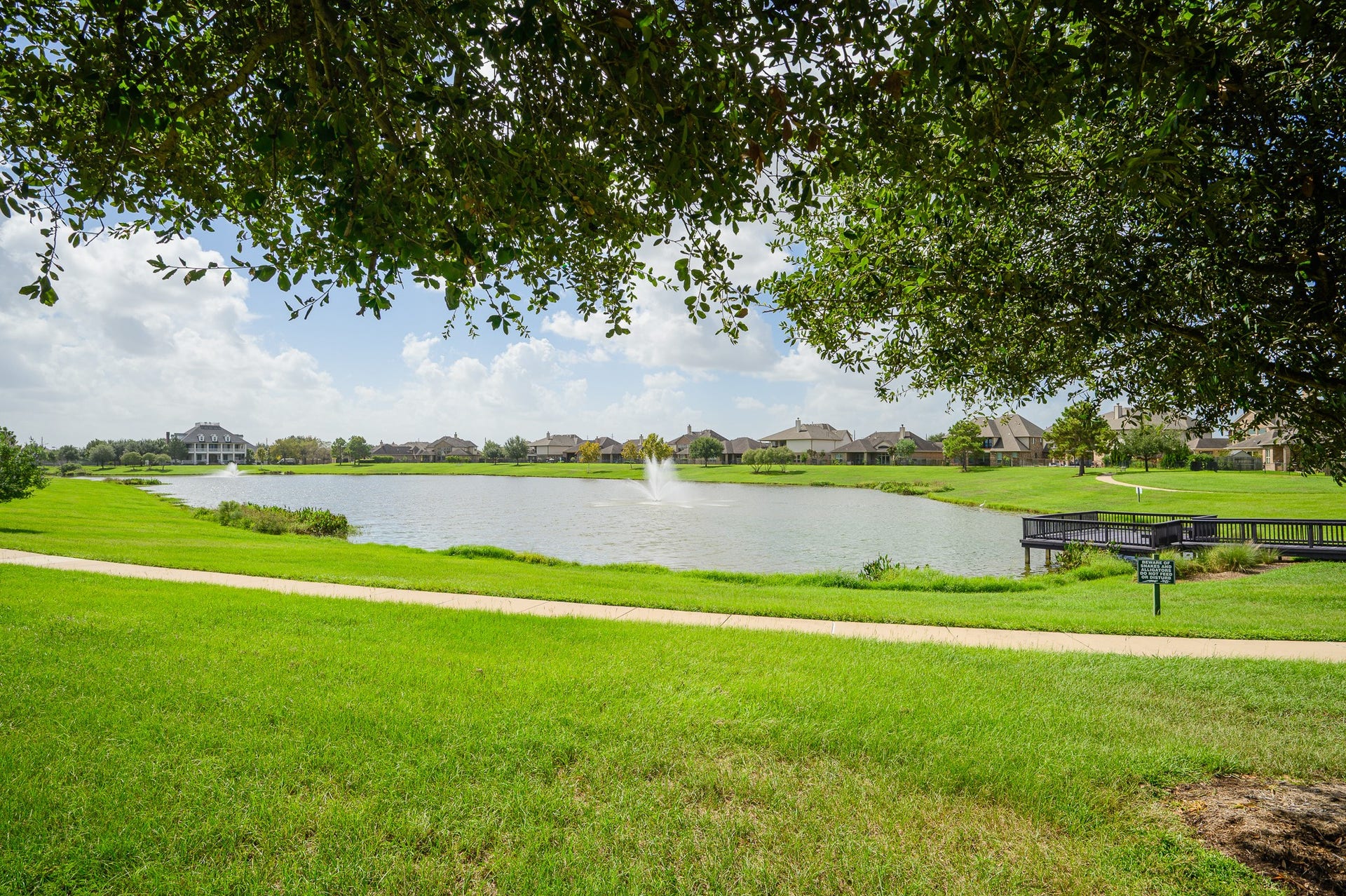 25610 Buckley Bluff Lane, Katy, TX 77494 Embrace serene lakeside living with a picturesque fountain, lush greenery, and a charming bridge, ideal for leisurely strolls and peaceful relaxation.
