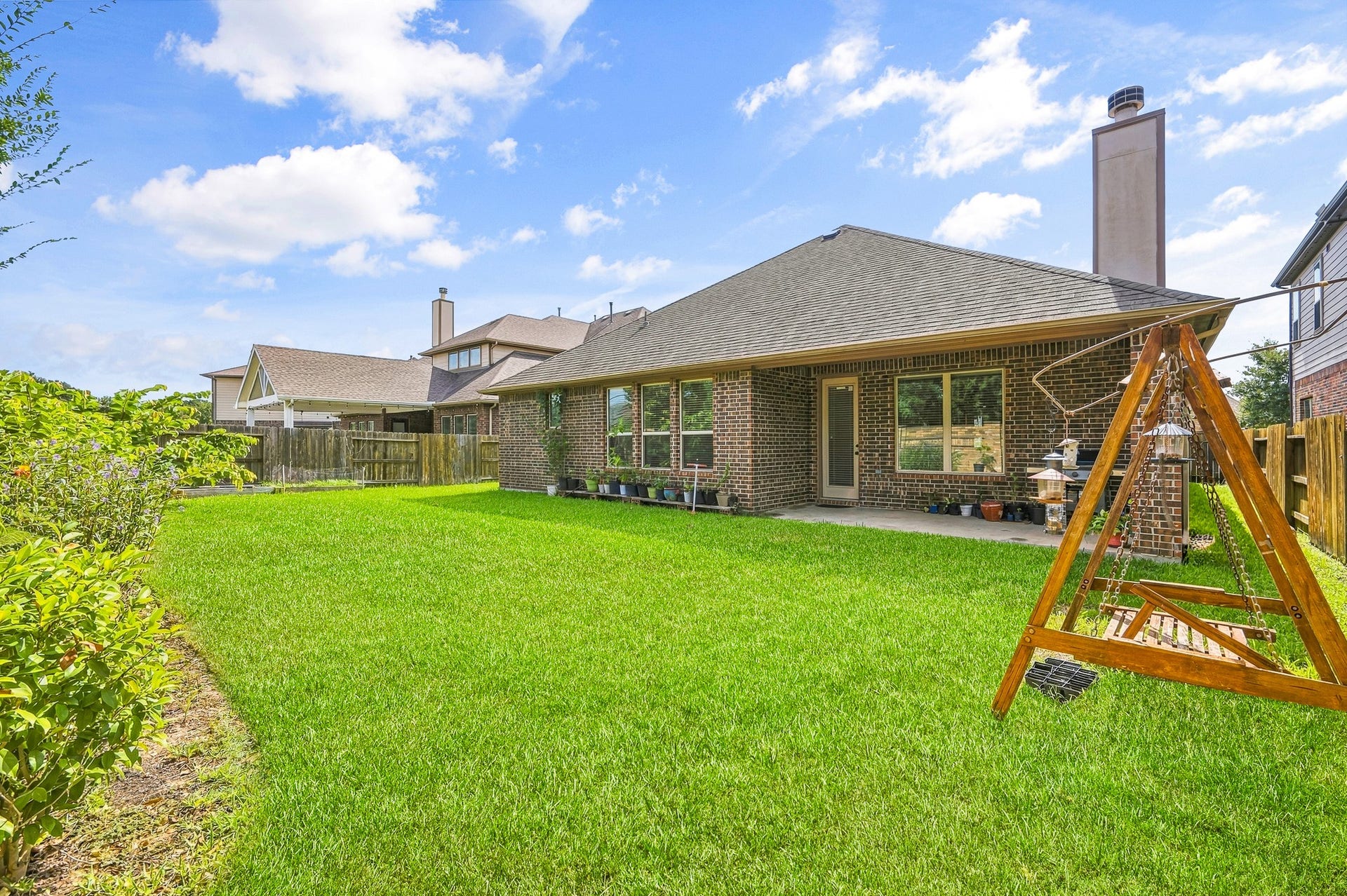 25610 Buckley Bluff Lane, Katy, TX 77494 Discover a charming backyard oasis with a spacious lawn, cozy swing set, and a covered patio ideal for relaxation and entertainment.
