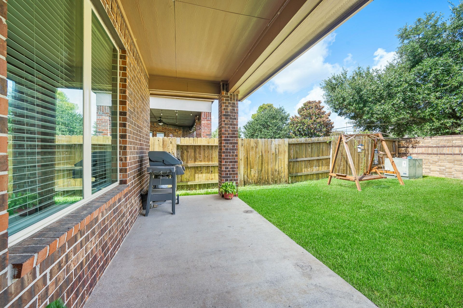 25610 Buckley Bluff Lane, Katy, TX 77494 Experience serene outdoor living and entertaining on a charming covered patio, seamlessly overlooking a lush, fenced backyard.