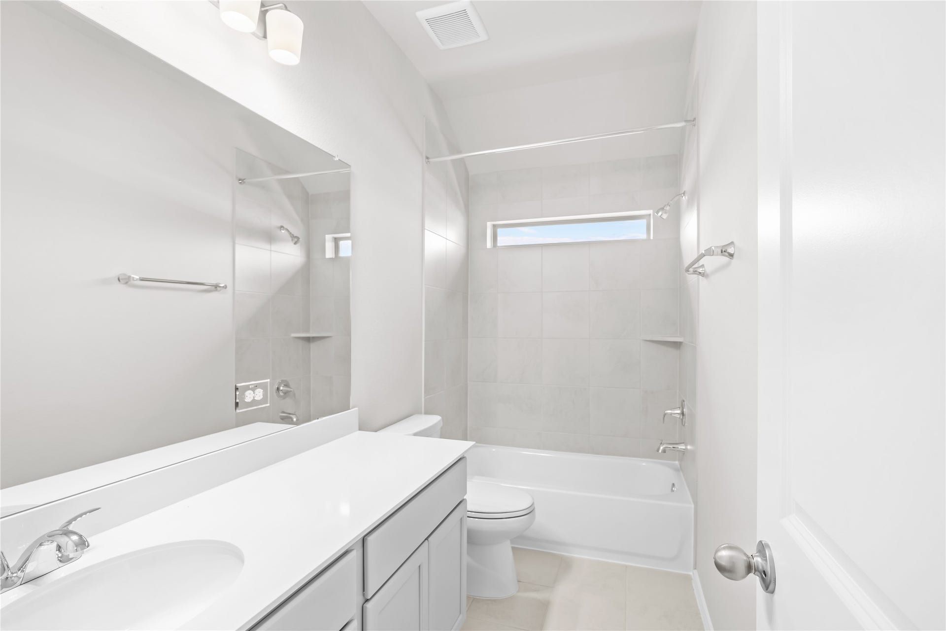 The secondary full bath features a single vanity, a tile tub shower combo and a privacy window.