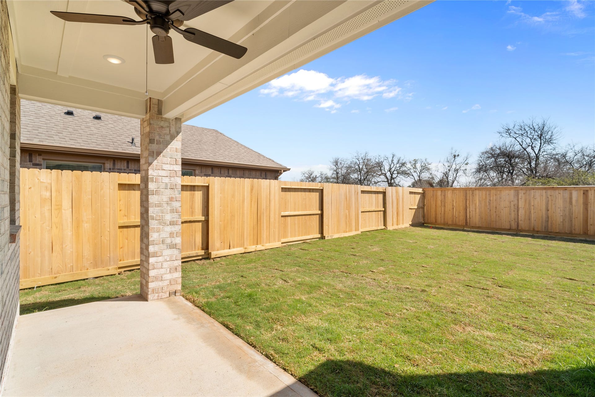 The covered back patio with ceiling fan extends your living space outdoors, perfect for hosting or relaxing.