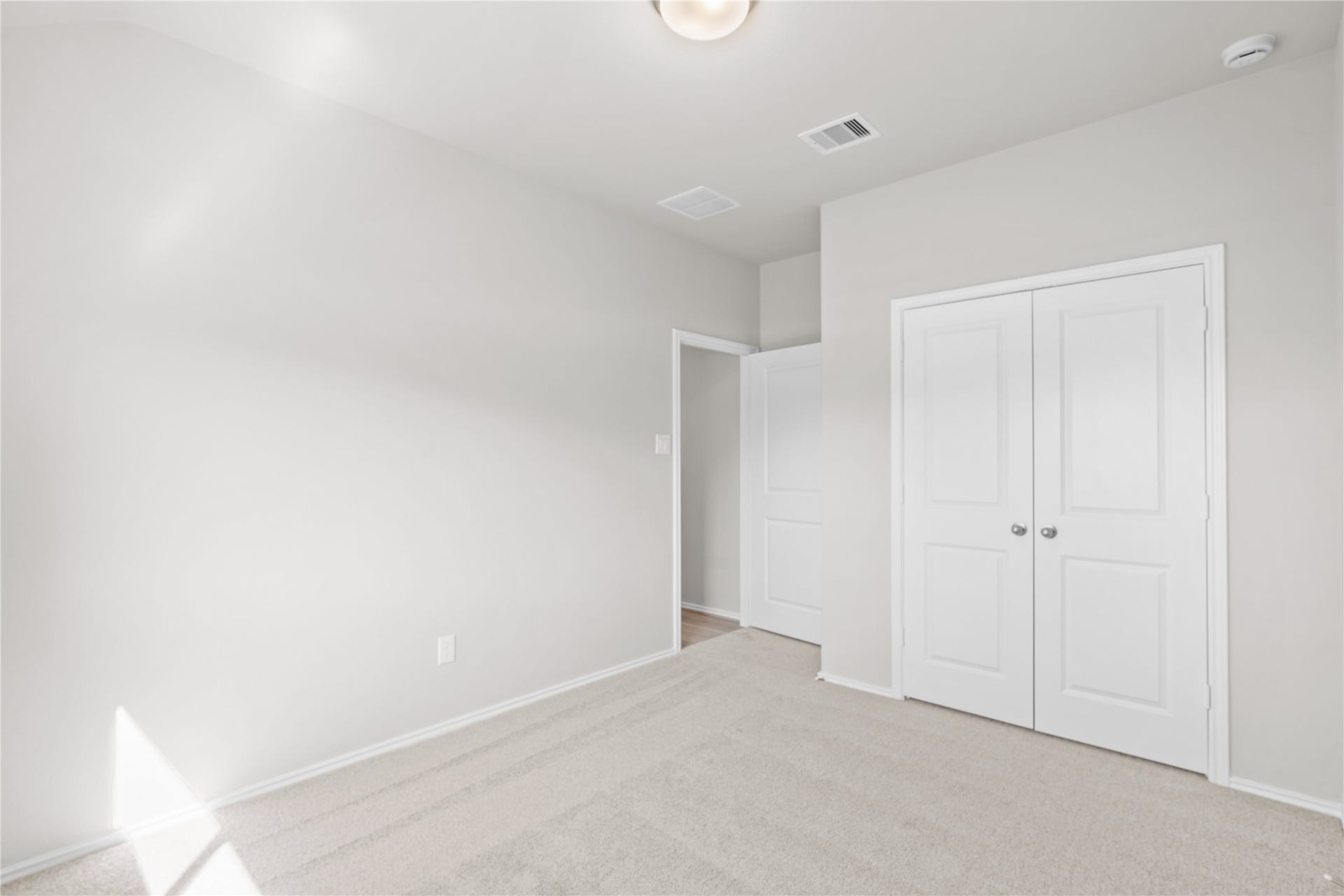 This secondary bedroom offers plush carpet, a double door closet and natural light.
