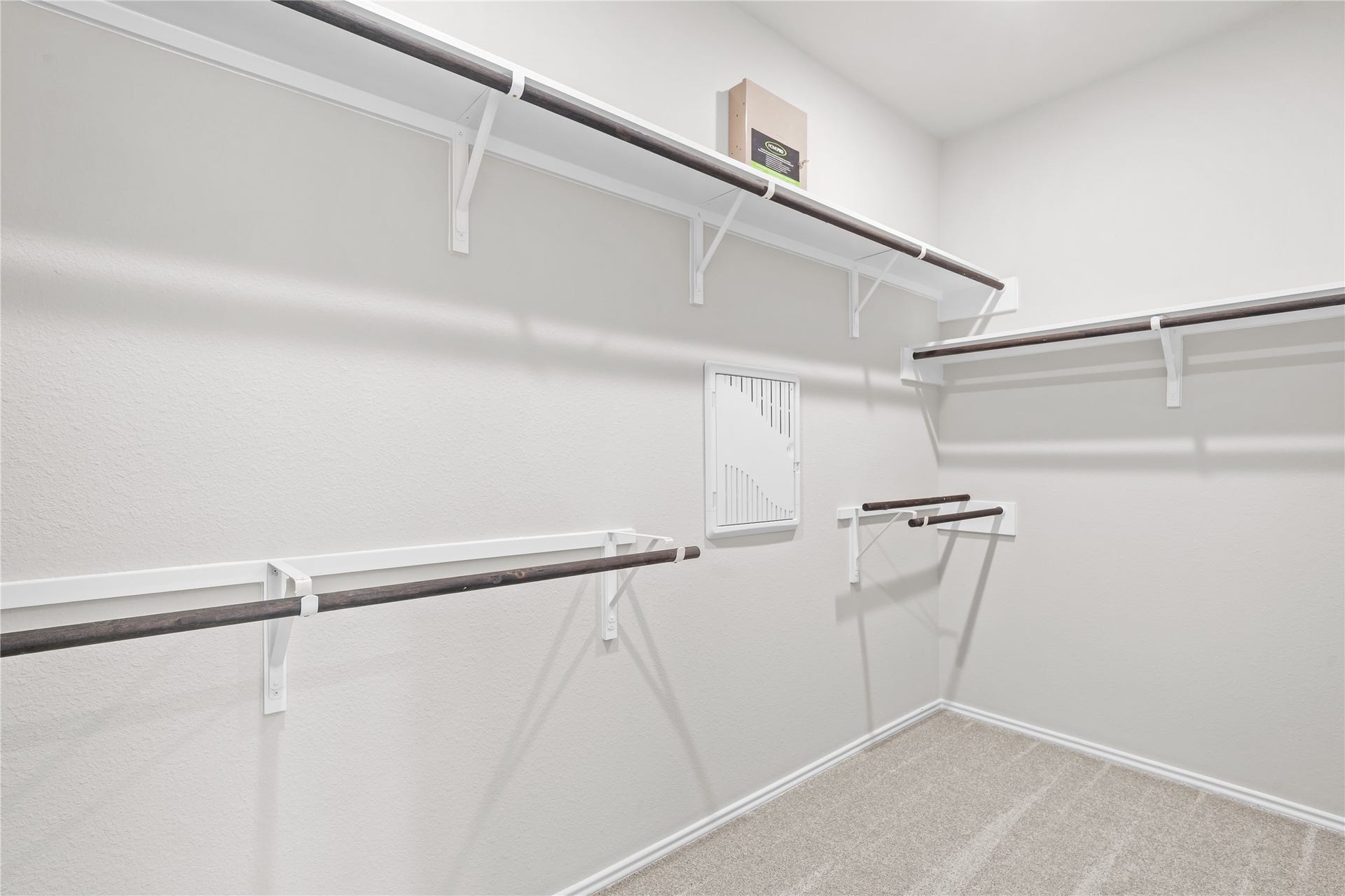 The primary walk in closet wraps hanging rods and shelving around three walls.