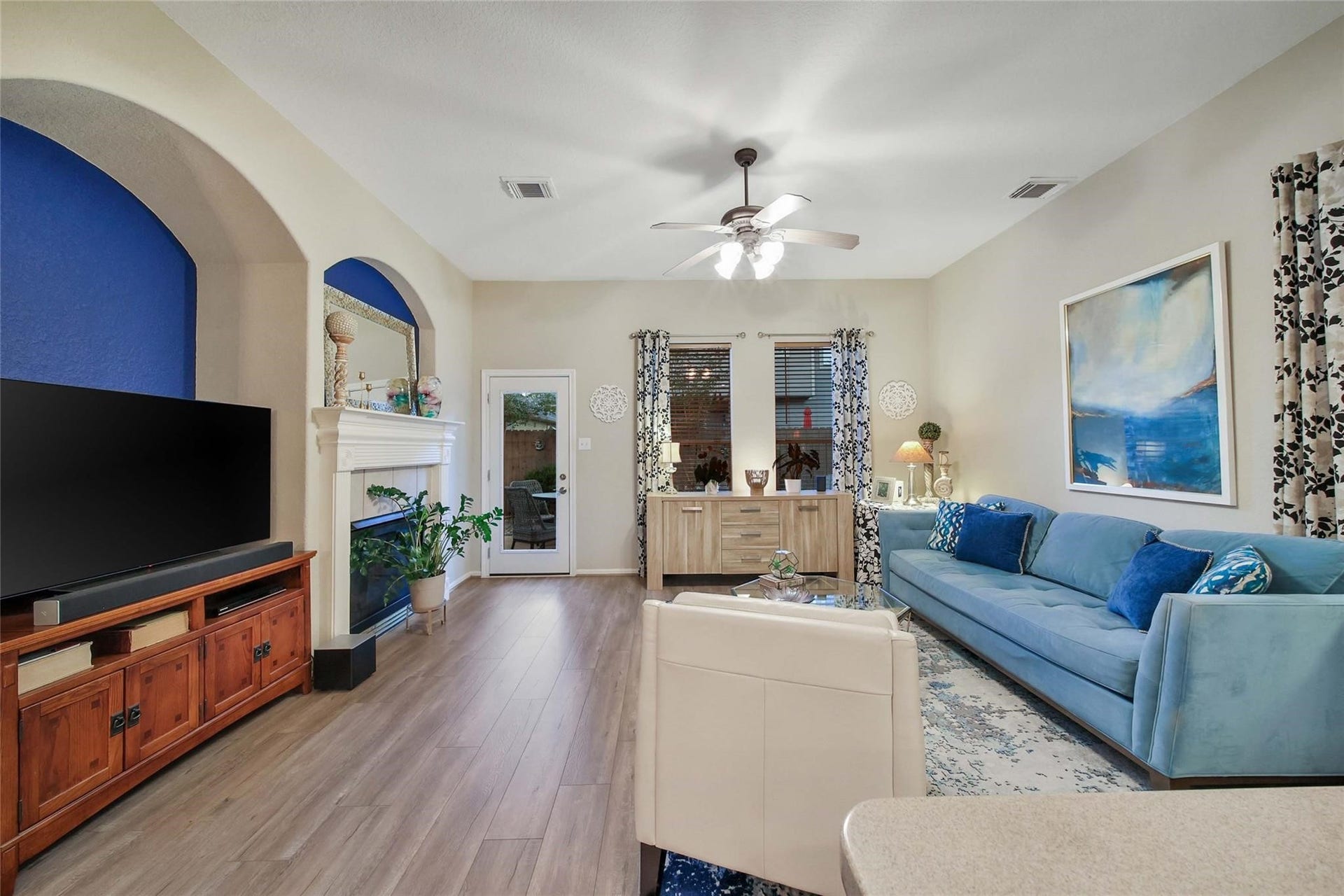 This is a bright and inviting dining space with tiled flooring, neutral wall colors, and an elegant chandelier. The dining area has an open archway leading to another room, offering a functional layout for entertaining and daily living.