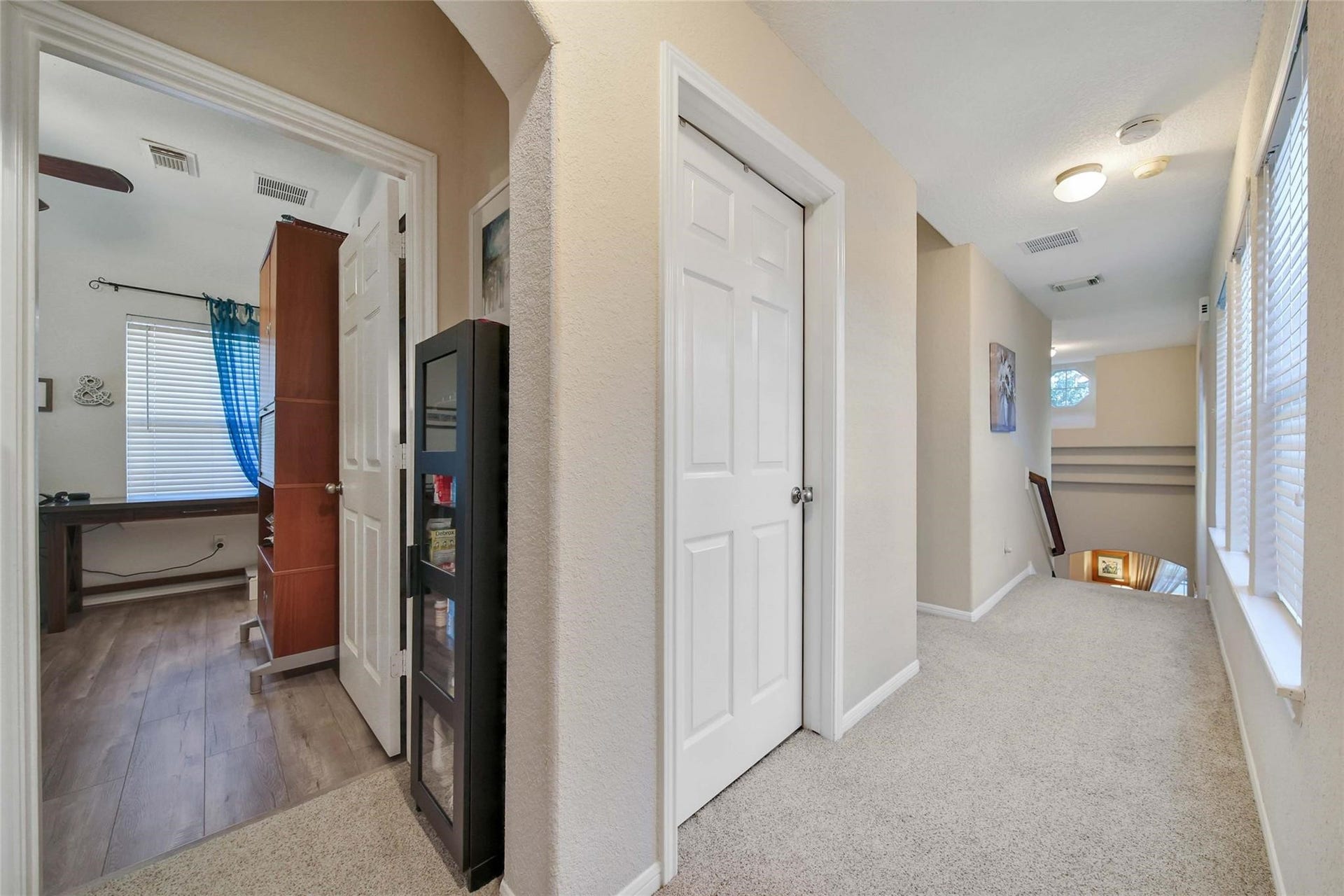This is a cozy, well-lit living room with hardwood floors, an elegant arched built-in shelf.