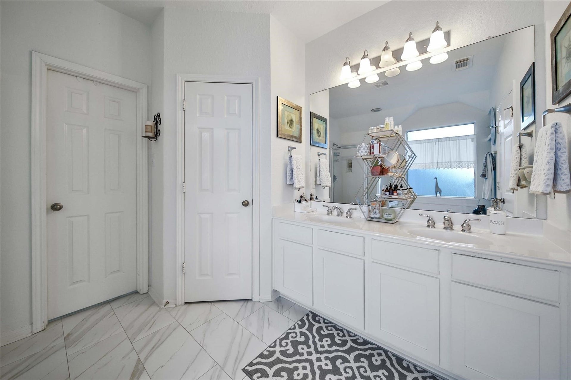 This is a spacious, well-lit Primary bedroom featuring a tray ceiling with a ceiling fan and large windows
