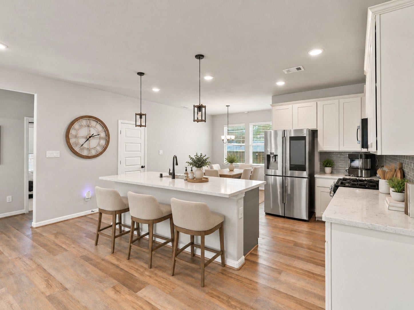 7814 Tindarey Maple Trace, Richmond, TX 77407 Open kitchen with a generous island, breakfast bar, white cabinetry, and an adjacent dining area.**Virtually staged