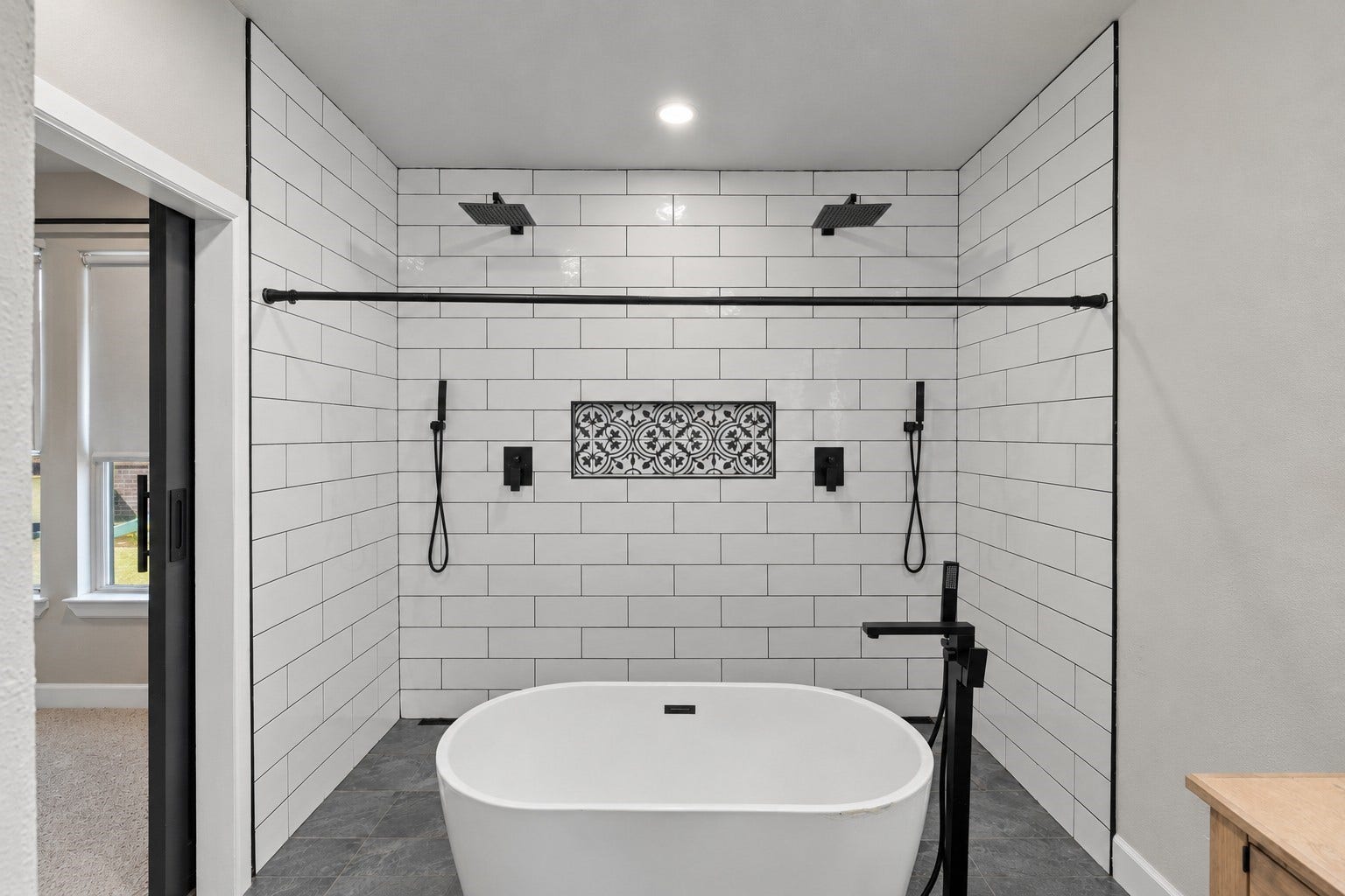7814 Tindarey Maple Trace, Richmond, TX 77407 Spa-inspired wet room featuring a freestanding soaking tub, dual rainfall showers, and decorative tile accents.
