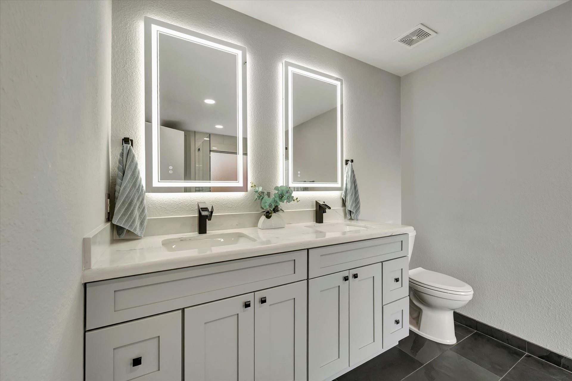 4802 Quiet Canyon Drive, Friendswood, TX 77546 Gorgeously renovated primary bathroom with double sinks and lighted mirrors.