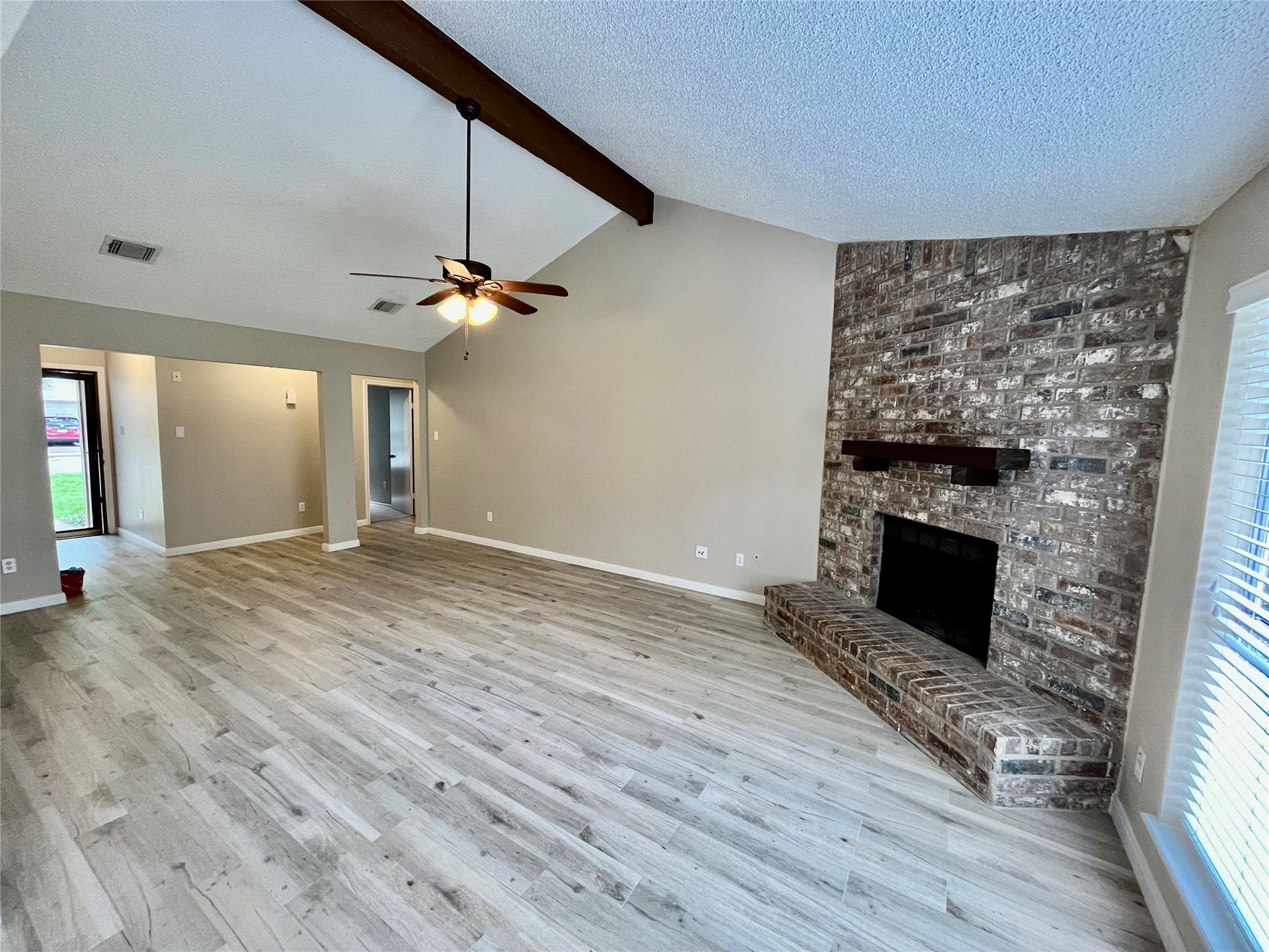 6 Leverwood Court, The Woodlands, TX 77381 Spacious great room featuring vaulted ceilings, a dramatic floor-to-ceiling brick fireplace, and abundant natural light.
