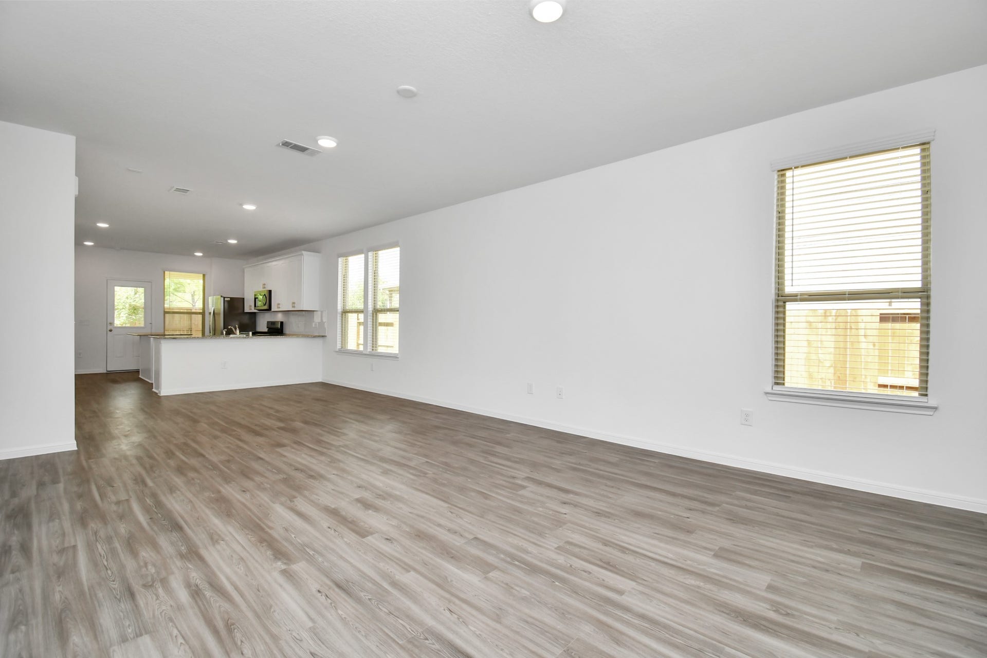 16150 Elbridge Court, Conroe, TX 77302 Upon stepping inside, you're immediately greeted by an abundance of natural light that bathes the open-concept living space. The interior design is a perfect blend of modern sophistication and warm, inviting elements. High ceilings and large windows create an airy and spacious atmosphere, while gleaming wood style floors flow throughout common areas, adding a touch of luxury.