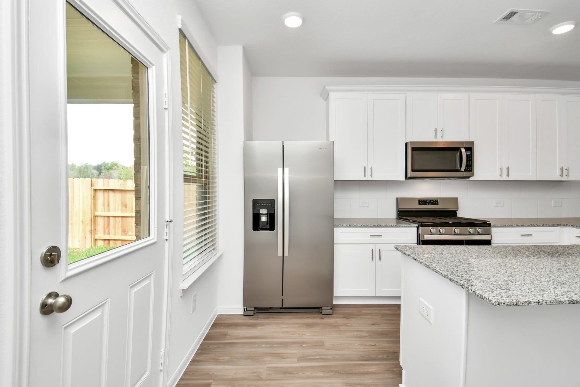 16150 Elbridge Court, Conroe, TX 77302 The kitchen blends indoor and outdoor living, with access to the back patio in a perfect blend of functionality, style, and the beauty of nature, creating a welcoming and versatile space.
