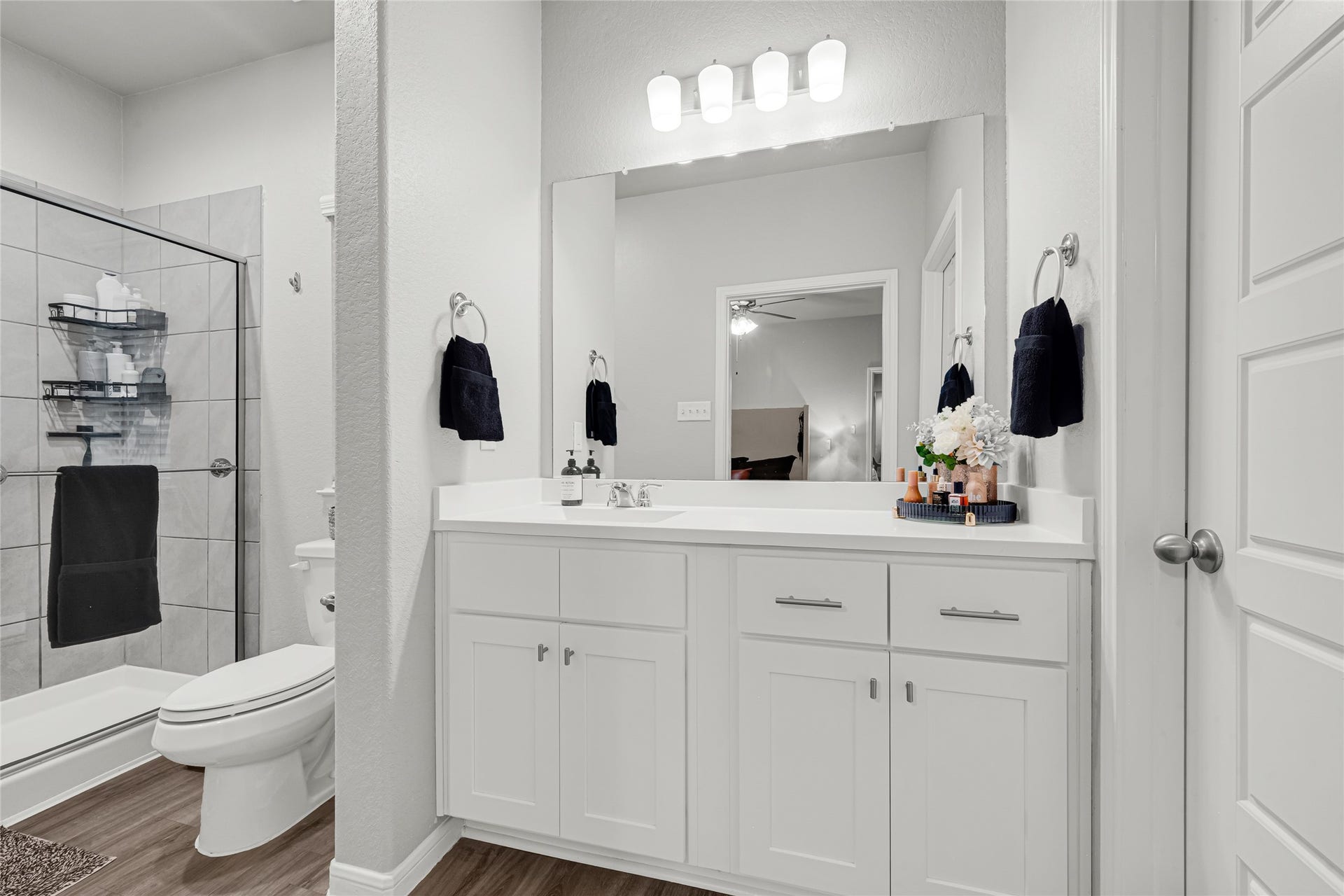 515 Emerald Thicket Lane, Houston, TX 77336 This bathroom features a modern design with a large mirror above a marble vanity countertop sink combo, elegant lighting. Birch cabinets to match kitchen, privacy door lock and satin nickle towel bar and paper holder. The neutral color palette and sleek Moen High Quality fixtures create a clean, inviting atmosphere.