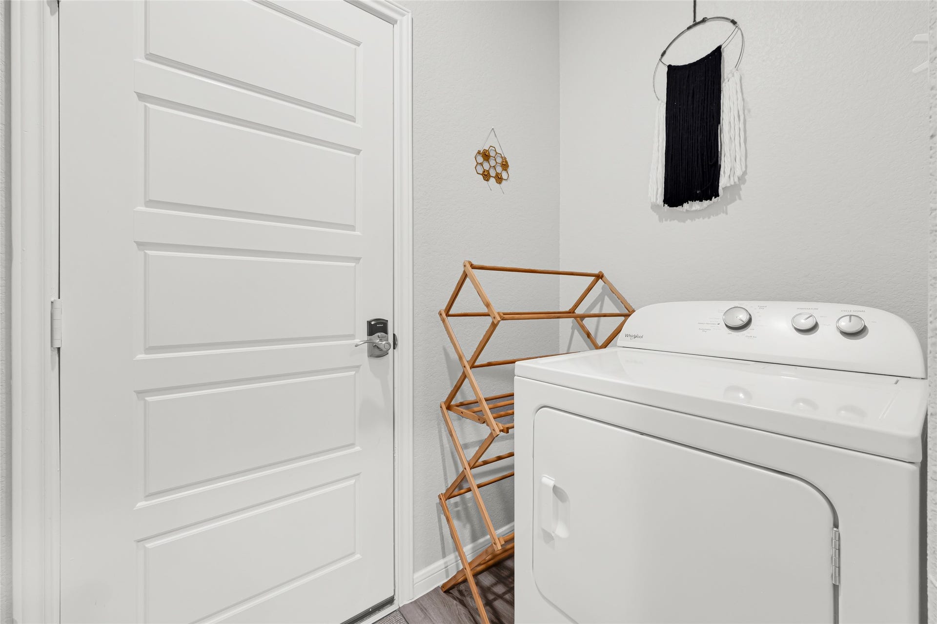 515 Emerald Thicket Lane, Houston, TX 77336 This sleek laundry room features a modern door connecting to the garage and seamlessly opens into the kitchen, offering both style and convenience.