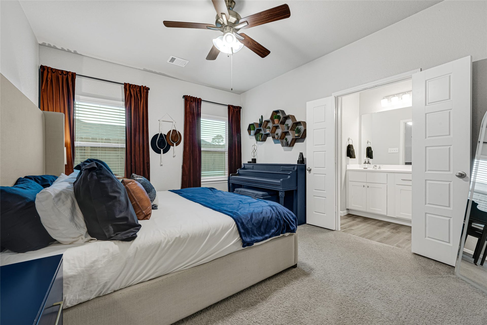 515 Emerald Thicket Lane, Houston, TX 77336 This perfectly sized bedroom features a neutral color palette with rich accents, the dark shade of the ceiling fan adds to the richness and over all feel of this cozy retreat.