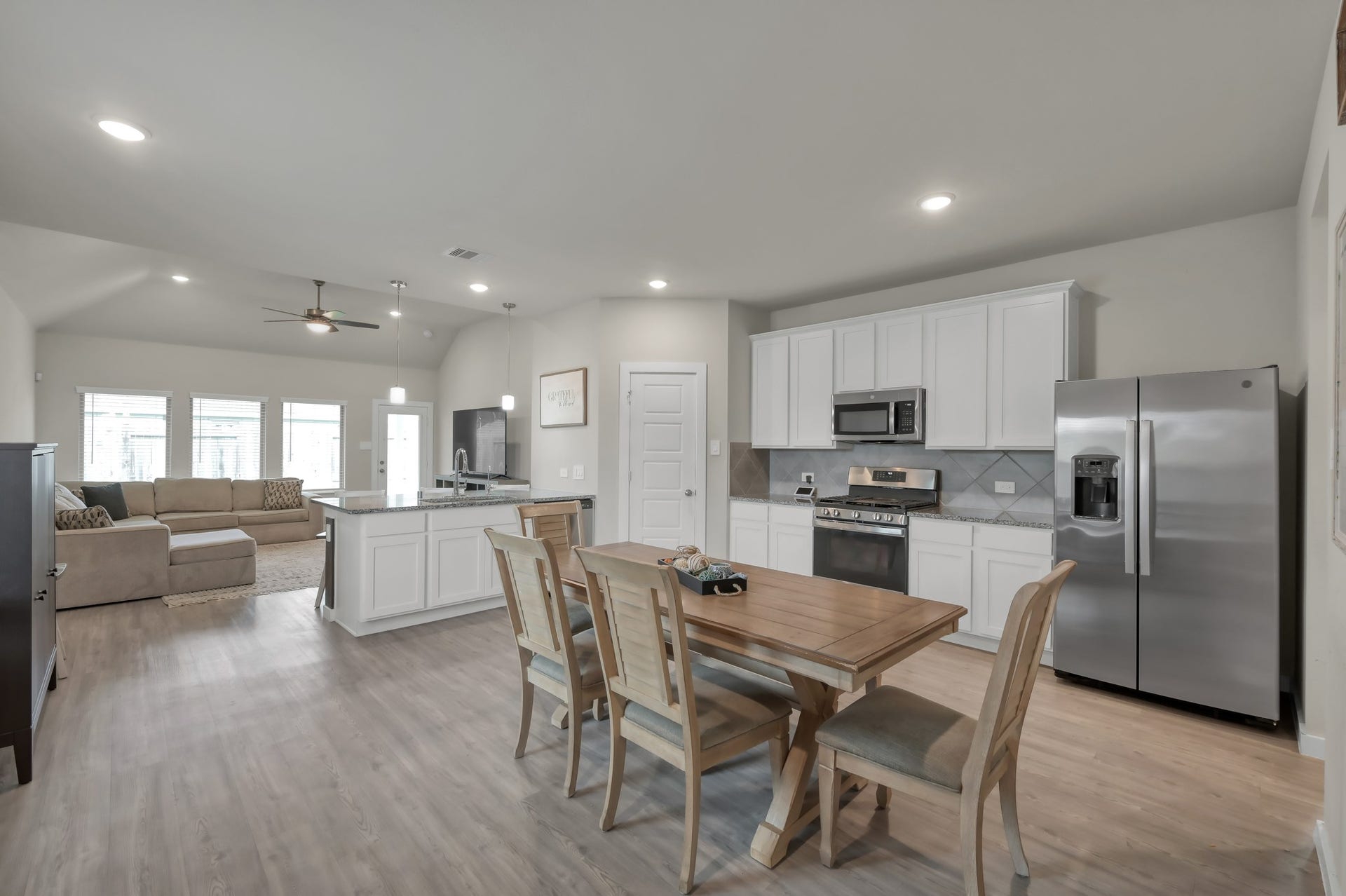 22203 Cardinal Crest Lane, New Caney, TX 77357 An open-concept kitchen and living area with modern appliances, a spacious dining table, and ample natural light. The layout is inviting and functional, perfect for both entertaining and everyday living.