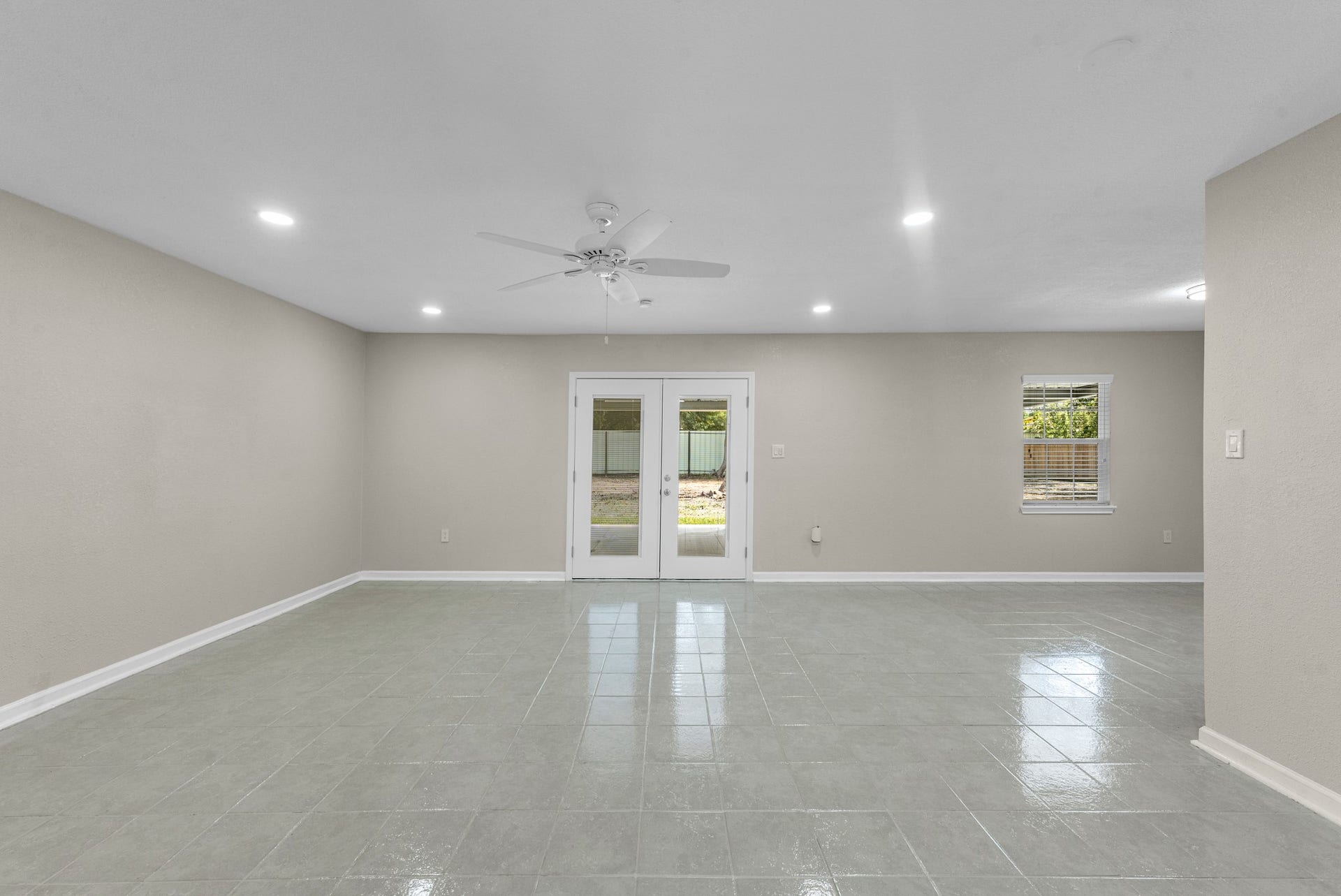 17435 Wells Drive, #CR115, Pearland, TX 77584 Step inside to the spacious living room, featuring updated tile flooring and French doors leading to the backyard.
