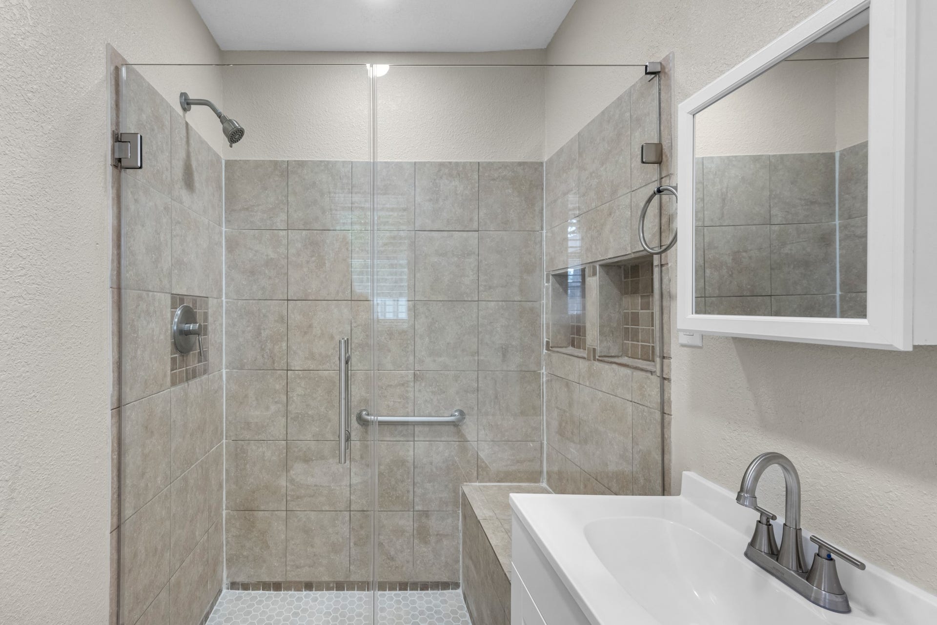 17435 Wells Drive, #CR115, Pearland, TX 77584 Step into the primary bath, featuring a walk-in tile shower with a glass enclosure and built-in niche.