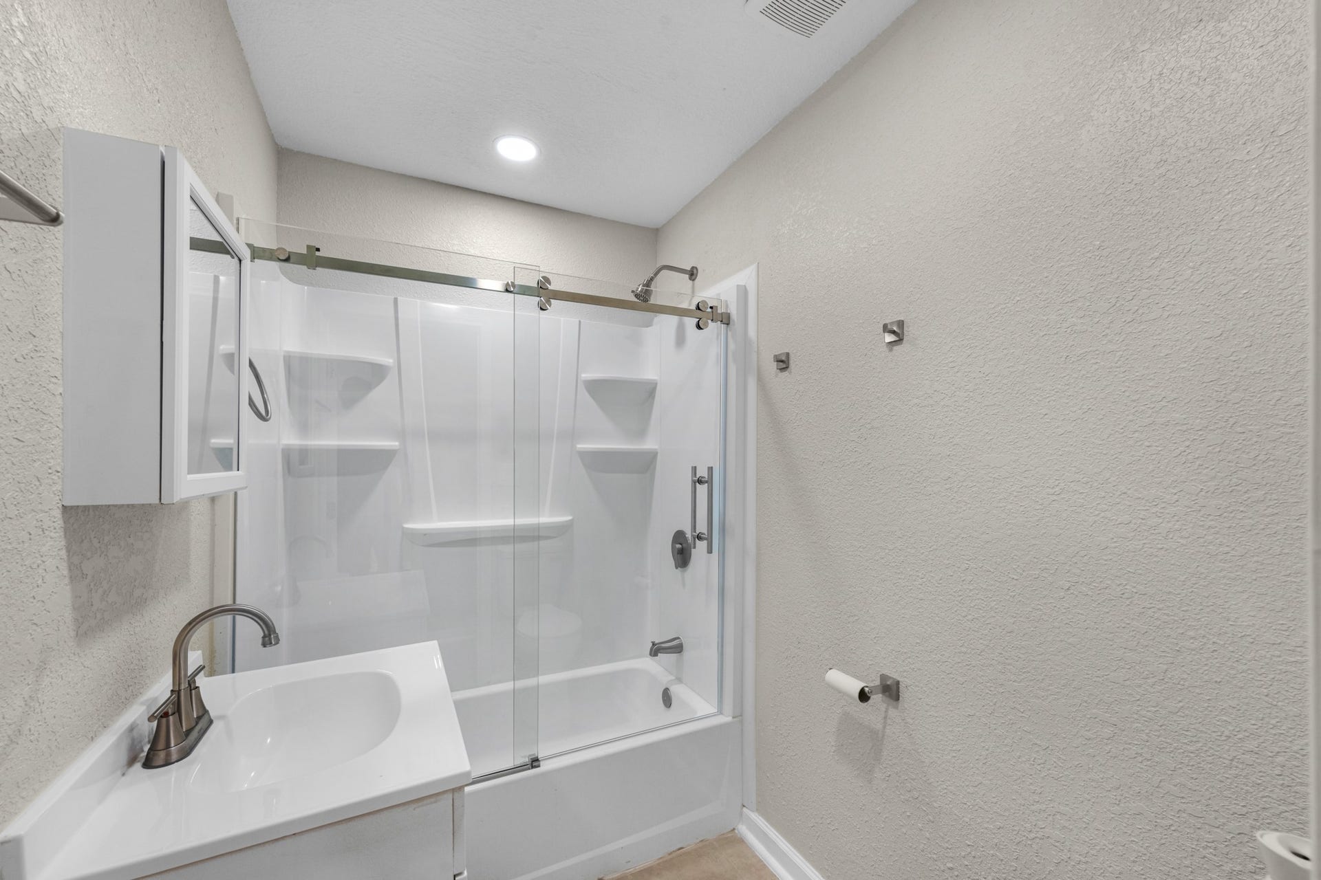 17435 Wells Drive, #CR115, Pearland, TX 77584 Nearby, the secondary bath features a tub and shower combination with a sliding glass door.