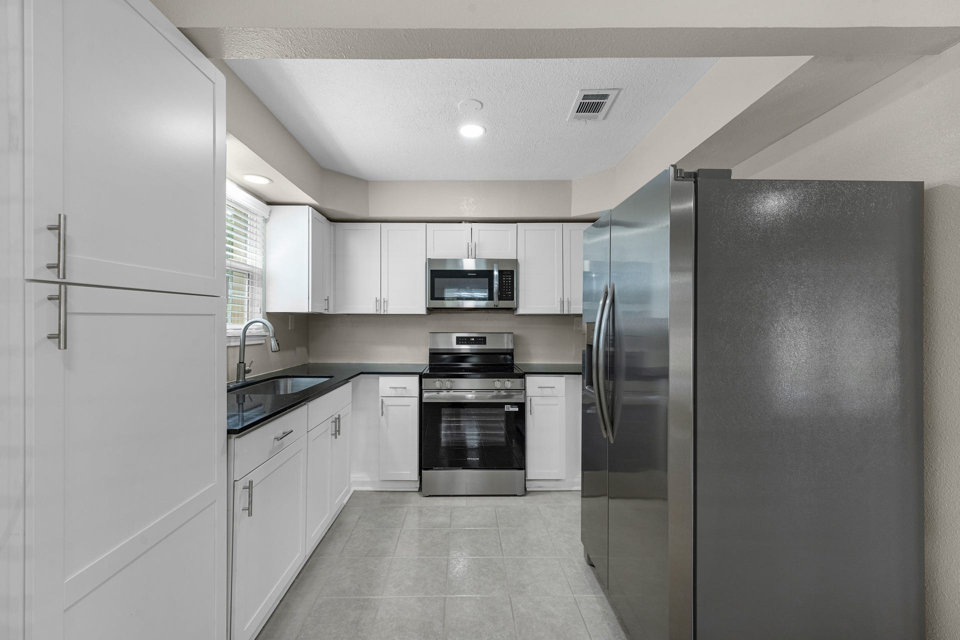 17435 Wells Drive, #CR115, Pearland, TX 77584 Step into the kitchen, lined with white shaker cabinetry.