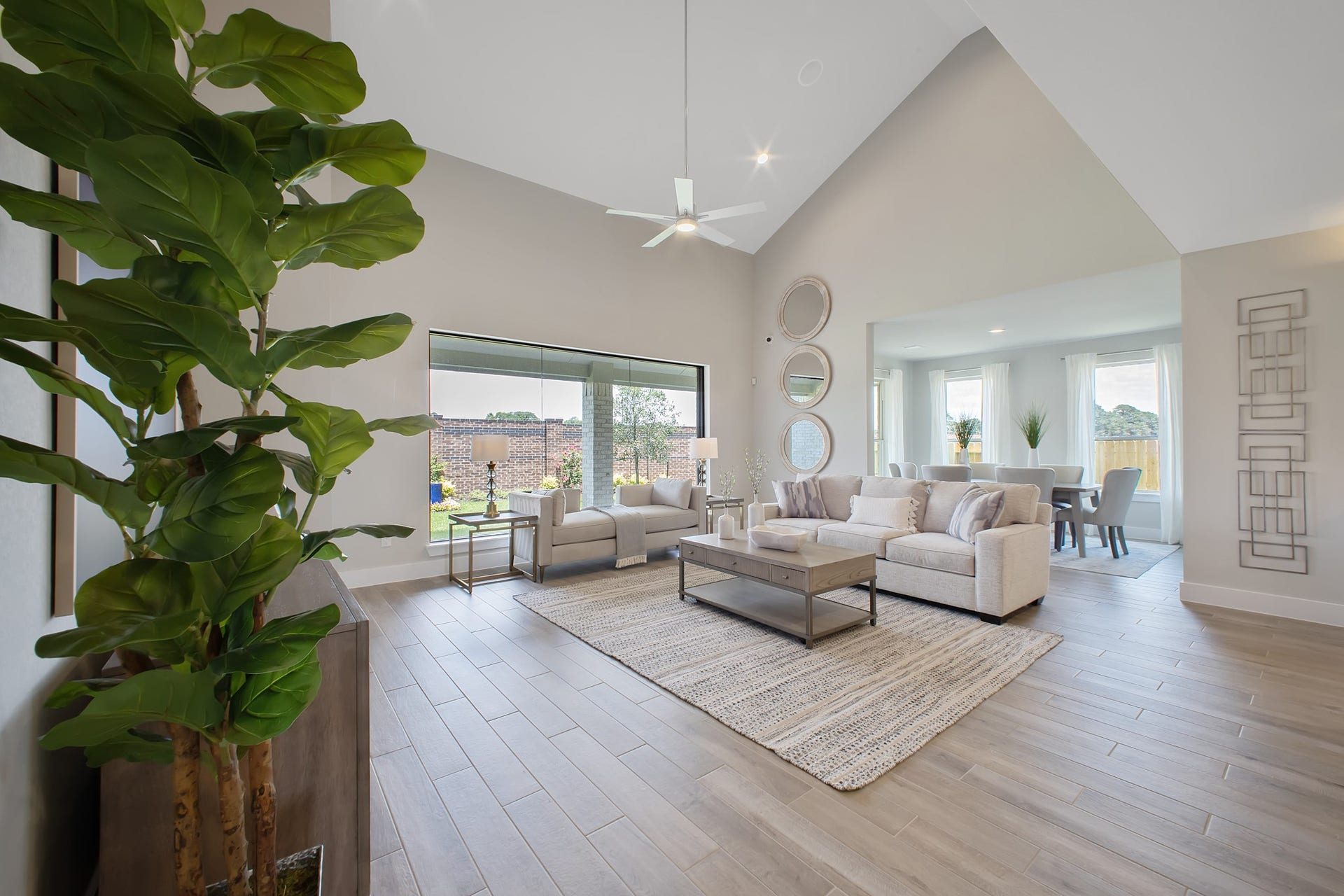 22122 Cortona Creek Lane, Hockley, TX 77447 Family room flooded with natural light through the expansive windows. The premium tile flooring adds a touch of luxury to the space, creating the perfect setting for relaxing moments and cherished gatherings with loved ones