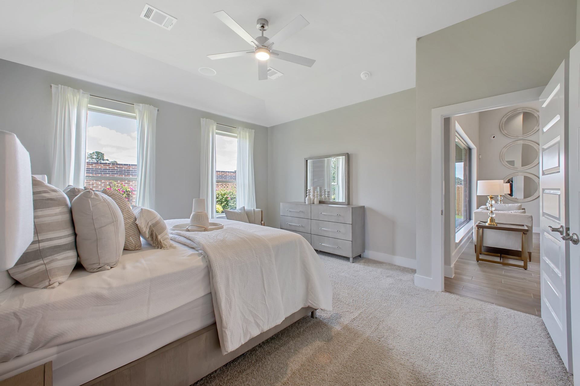 22122 Cortona Creek Lane, Hockley, TX 77447 Escape to tranquility in this spacious primary room, adorned with plush carpeting and bathed in the soothing hues of warm paint colors, creating a cozy retreat for relaxation.