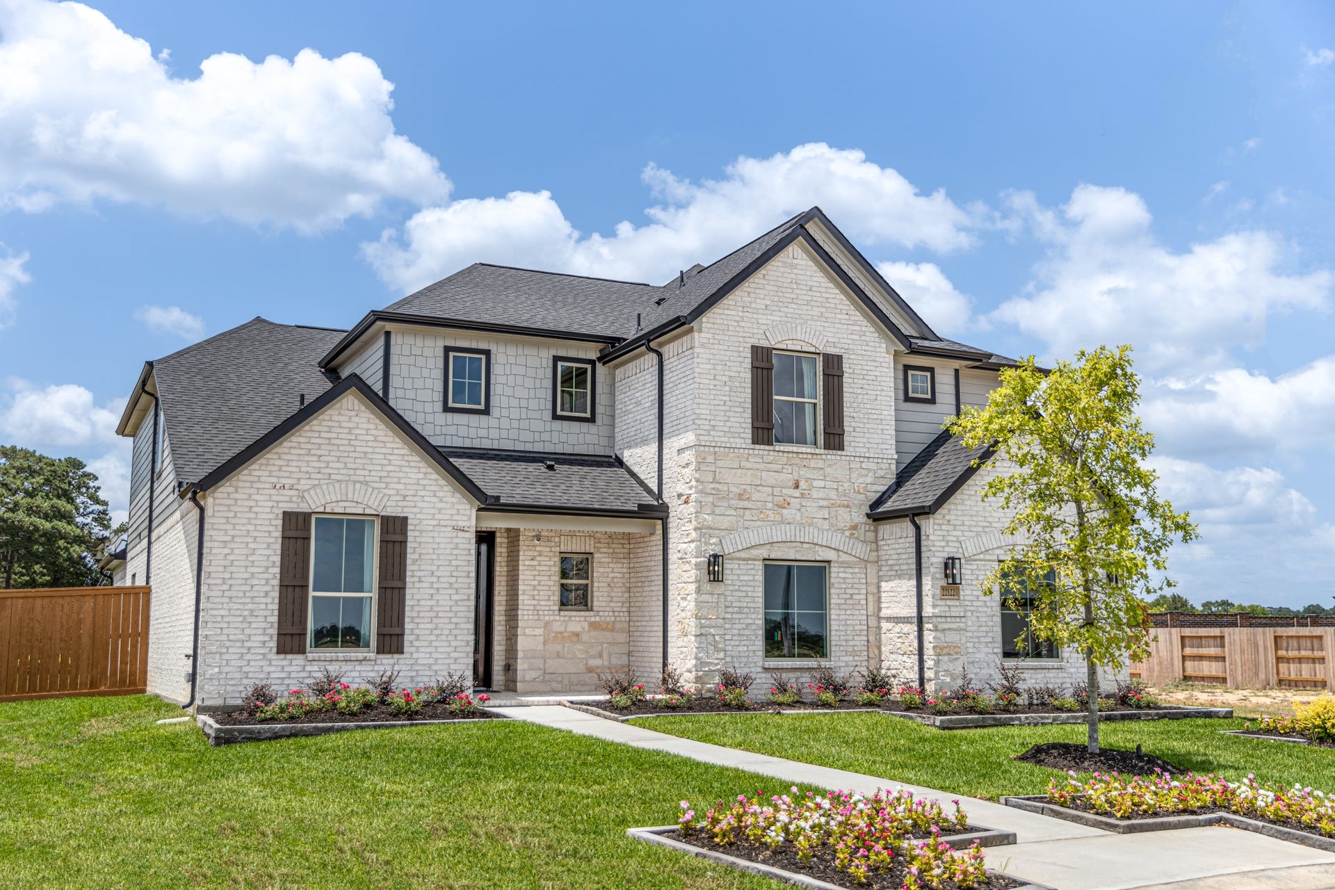 22122 Cortona Creek Lane, Hockley, TX 77447 The residence features a practical 2-car garage complemented by a generous driveway, ensuring abundant space for parking needs.