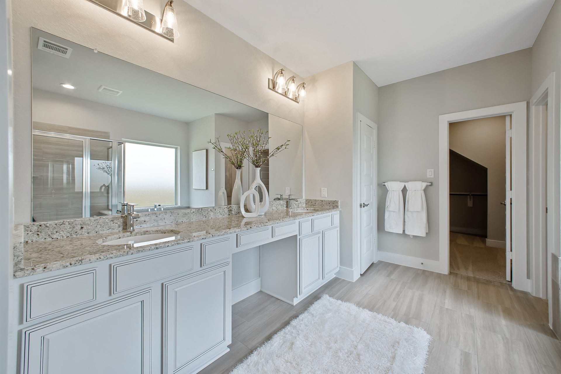 22122 Cortona Creek Lane, Hockley, TX 77447 Elevate your daily routine at the elegant vanity, now equipped with double sinks, light countertops, modern hardware, and beautiful vanity lights.