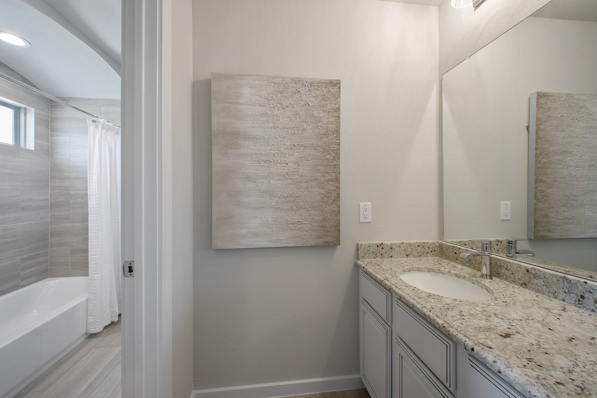 22122 Cortona Creek Lane, Hockley, TX 77447 Secondary bath features tile flooring, bath/shower combo with tile surround, light stained wood cabinets, beautiful light countertop.