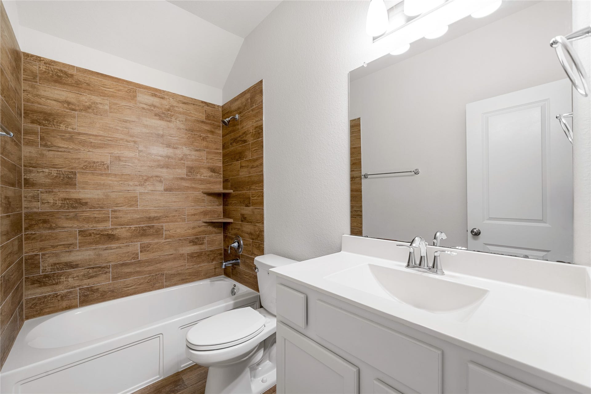 2418 Green Kale Drive, Richmond, TX 77406 This well-appointed full bath offers a vanity with ample storage, a large mirror, and a tub/shower combo with beautiful wood-look tile surround!