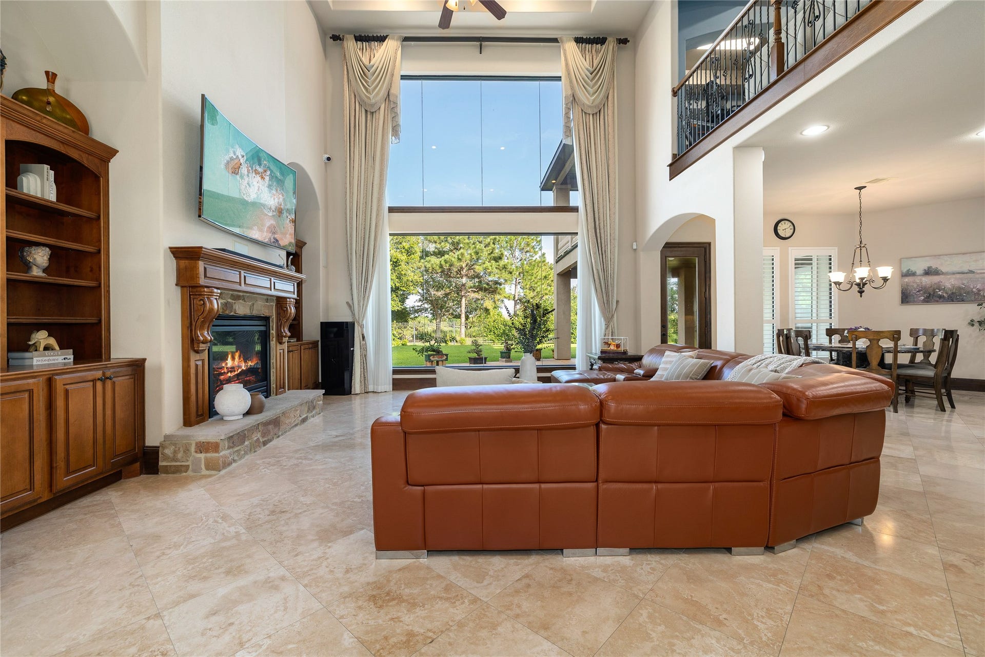 27711 Charter Lake Lane, Katy, TX 77494 Spacious family room with custom built-ins, statement fireplace, soaring ceilings, and breathtaking waterfront views.