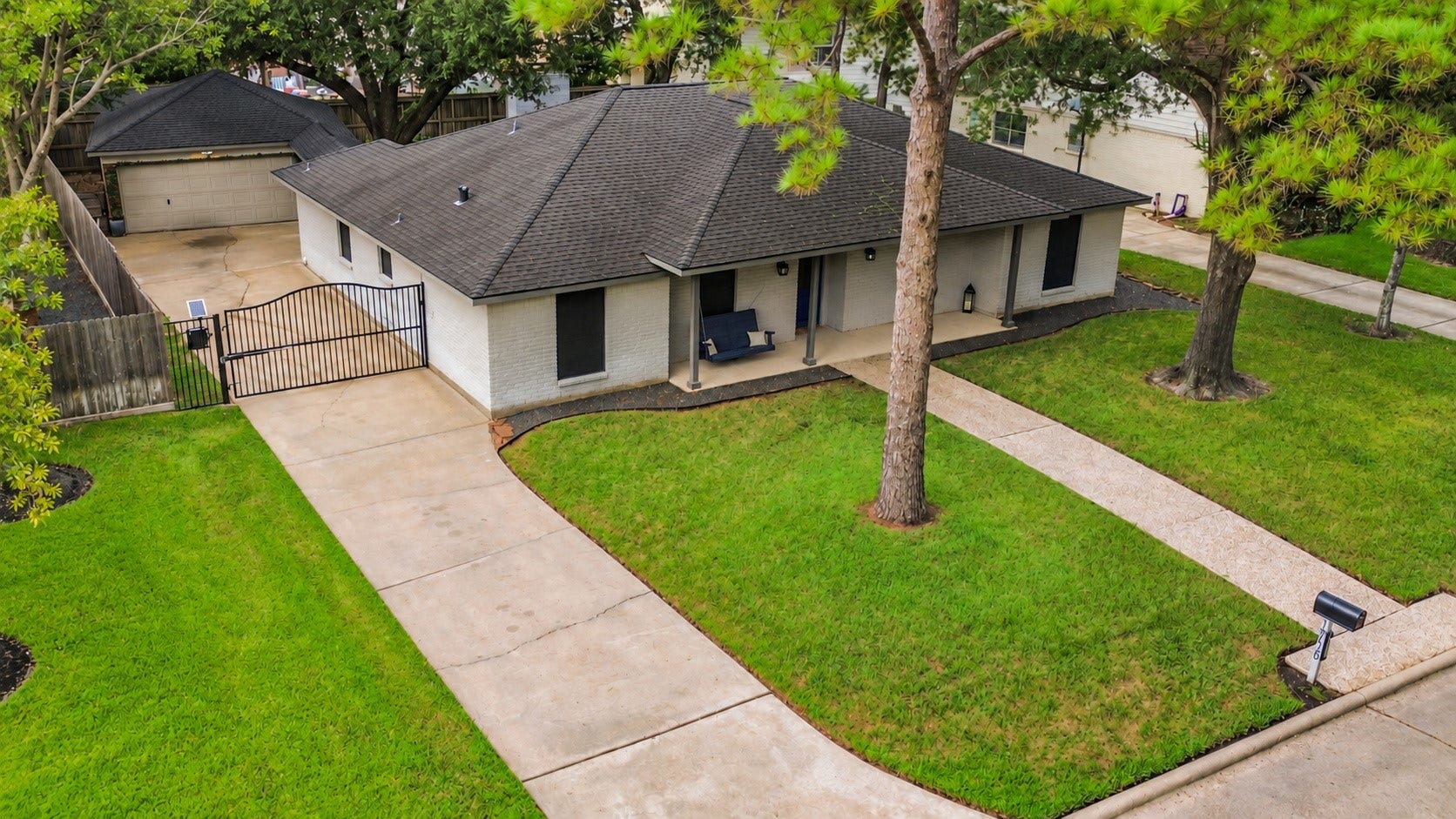 Even has an electronic gate for added privacy and convenience! Enjoy a porch swing on the covered patio! The detached garage is a real bonus and offers a covered walkway from the house.
