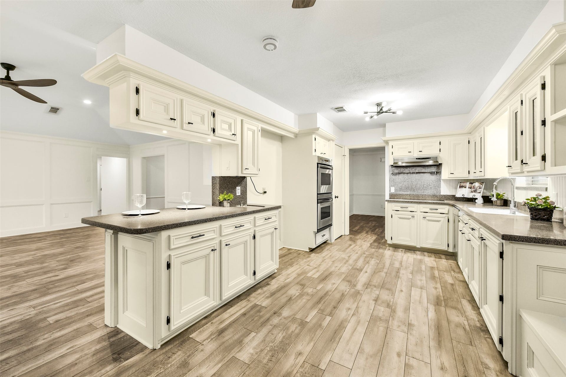 The kitchen offers plenty of cabinets, under cabinet lighting, updated countertops, double oven, double sinks & more!
