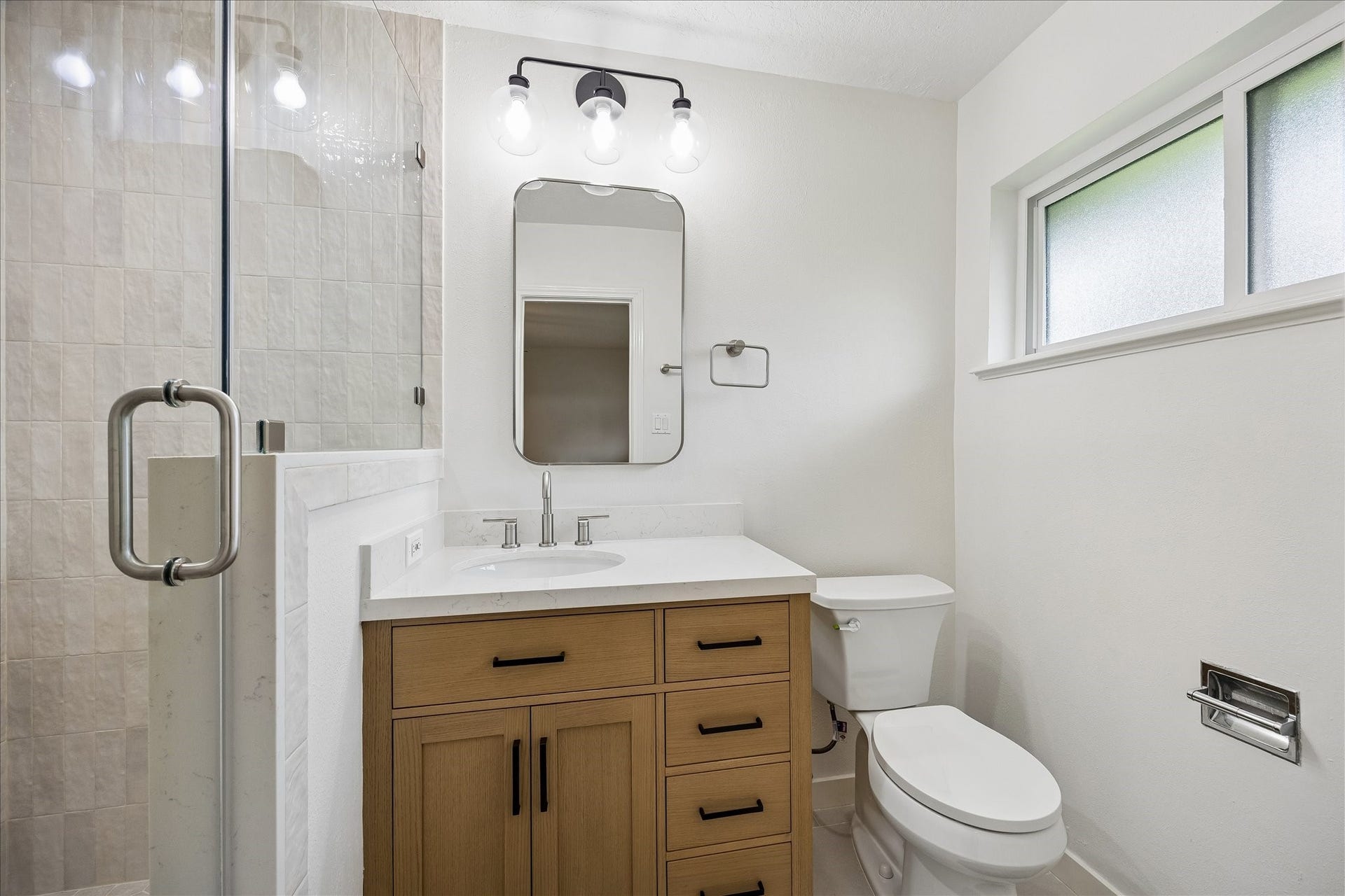 Completely remodeled bathroom with a new vanity and large walk-in shower.