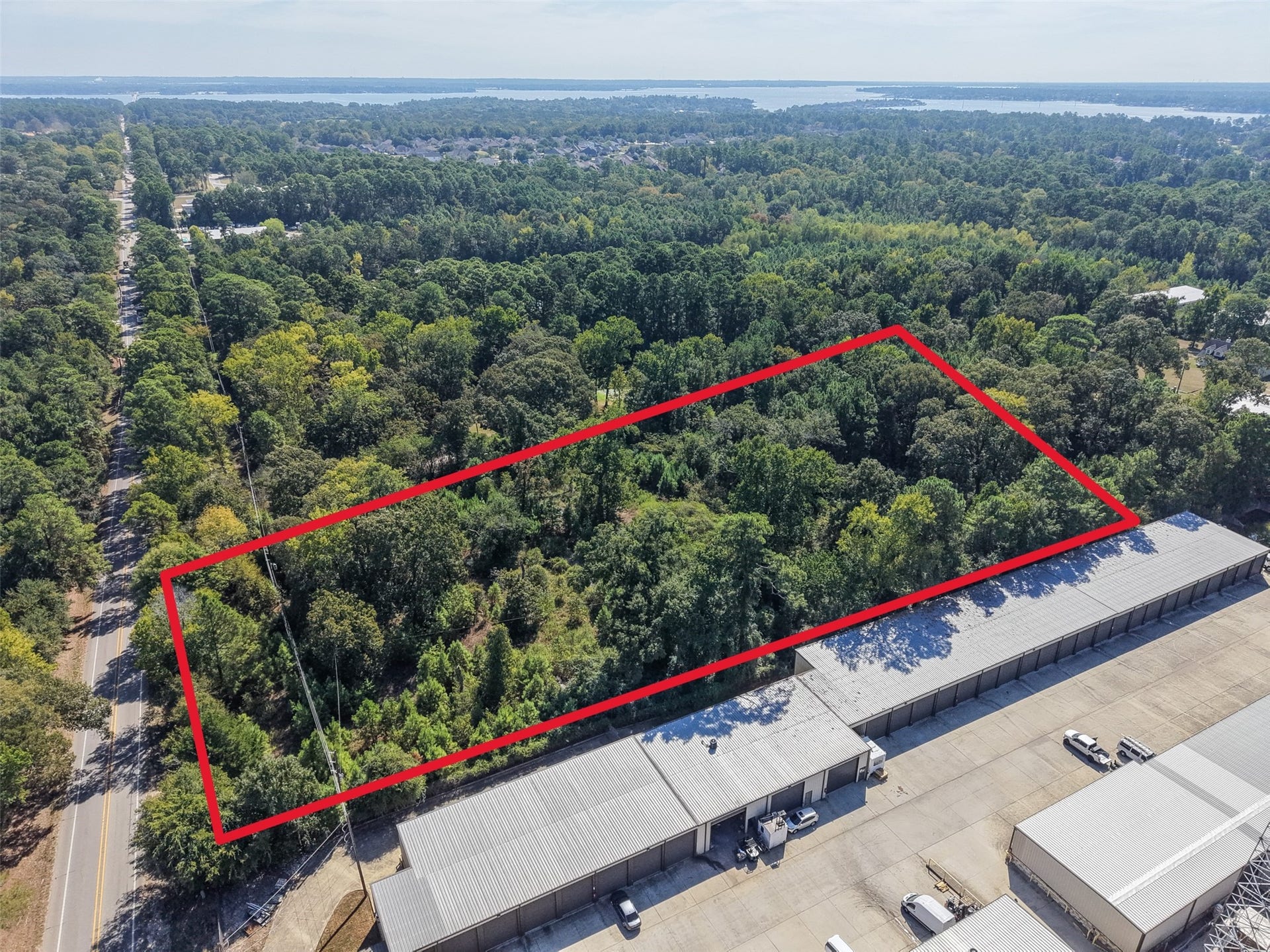 18841 W Fm 1097 Road, Montgomery, TX 77356 Clearly defined aerial view highlighting the property's configuration, mature tree coverage, and proximity to neighboring commercial improvements. Road frontage and the nearby Lake Conroe area contribute to this tract's investment and development appeal.