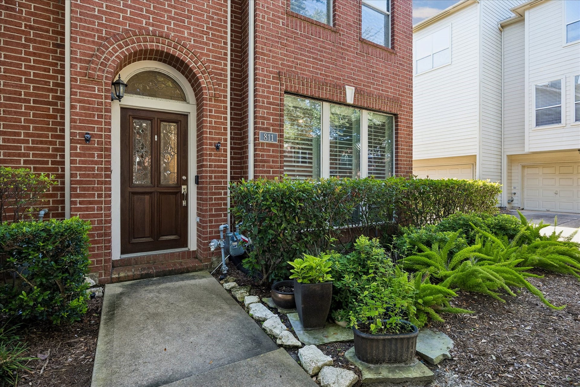 811 W Heights Hollow Lane, Houston, TX 77007 Inviting entry surrounded by lush lawn and mature trees throughout the whole community! The lawn is maintained by the HOA.