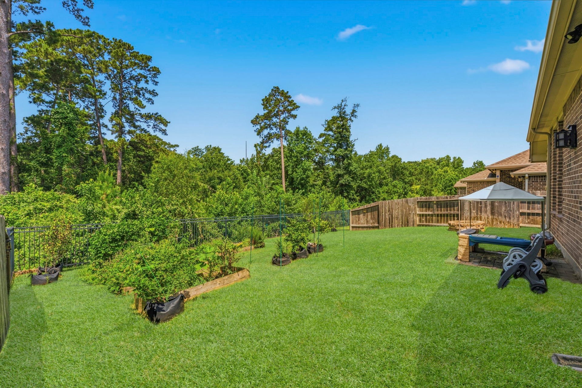 2143 Moss Creek Lane, Conroe, TX 77304 Garden enthusiasts will appreciate the irrigated garden beds, currently flourishing with tomatoes, okra, green bell peppers, strawberry plants, multiple varieties of basil, dill, and colorful seasonal flowers.