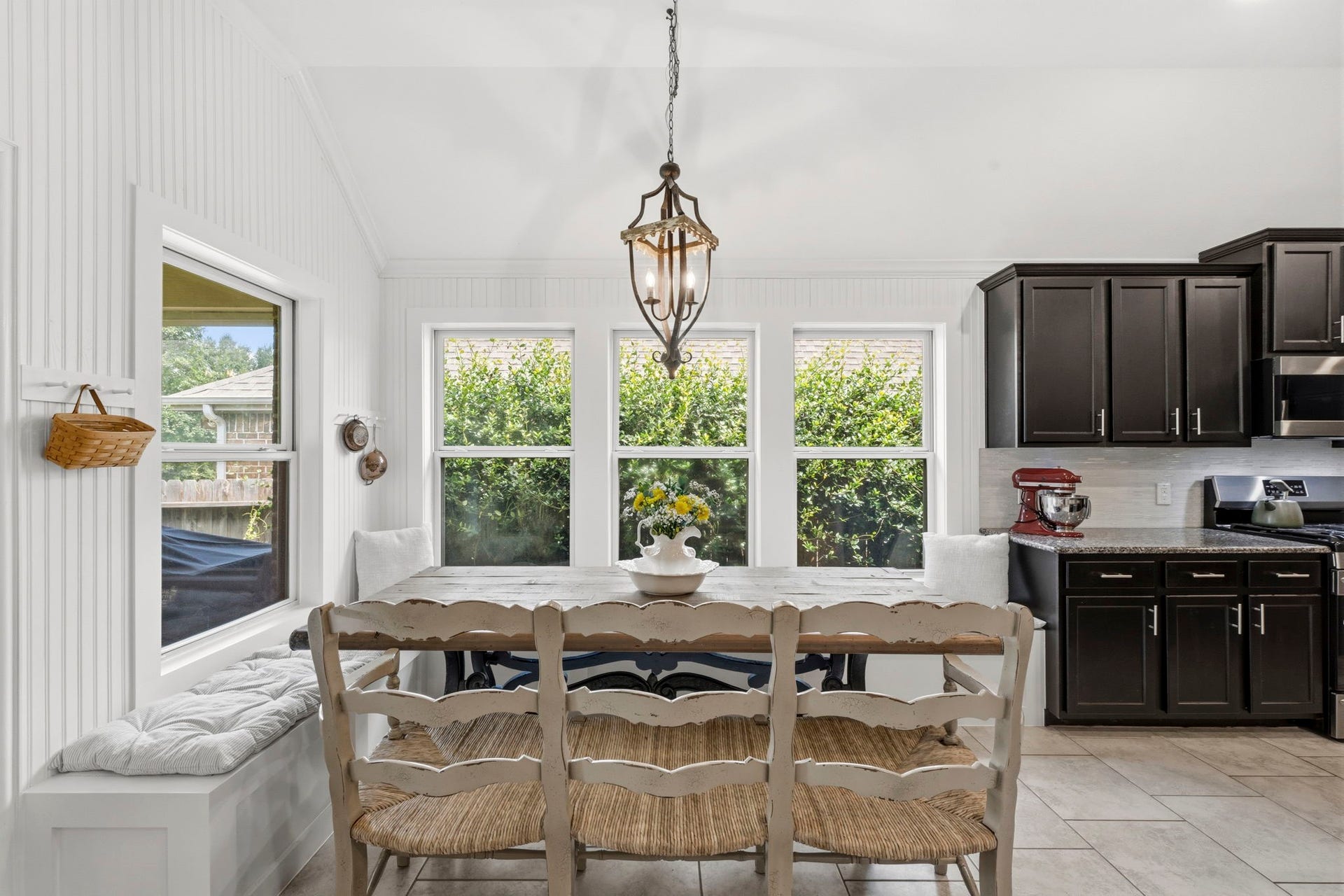 2143 Moss Creek Lane, Conroe, TX 77304 Enjoy meals in the sun-filled dining room, ideally situated between the kitchen and living area. Blinds were removed for cafe curtains and are currently stored inside the bench. Jasmine trellises outside provide privacy & attract Hummingbirds!