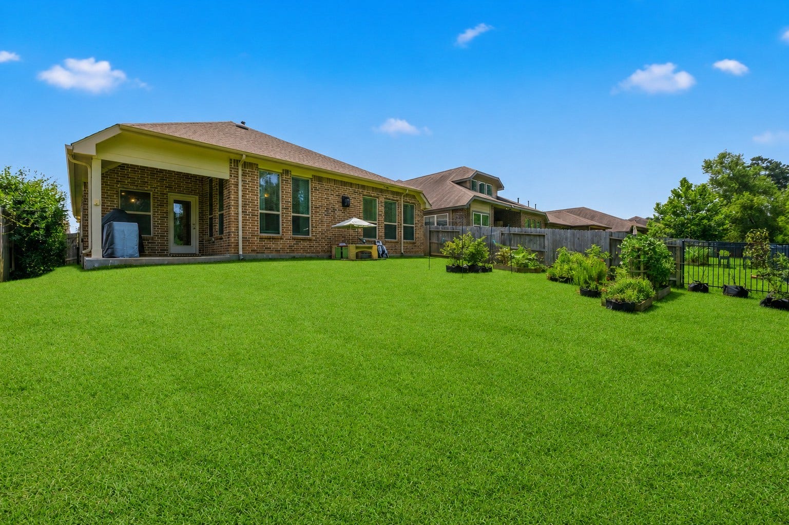 2143 Moss Creek Lane, Conroe, TX 77304 The beautifully fenced backyard offers endless possibilities, with fragrant jasmine trellises outside the dining room and side bedroom windows providing natural privacy while attracting hummingbirds throughout the seasons.