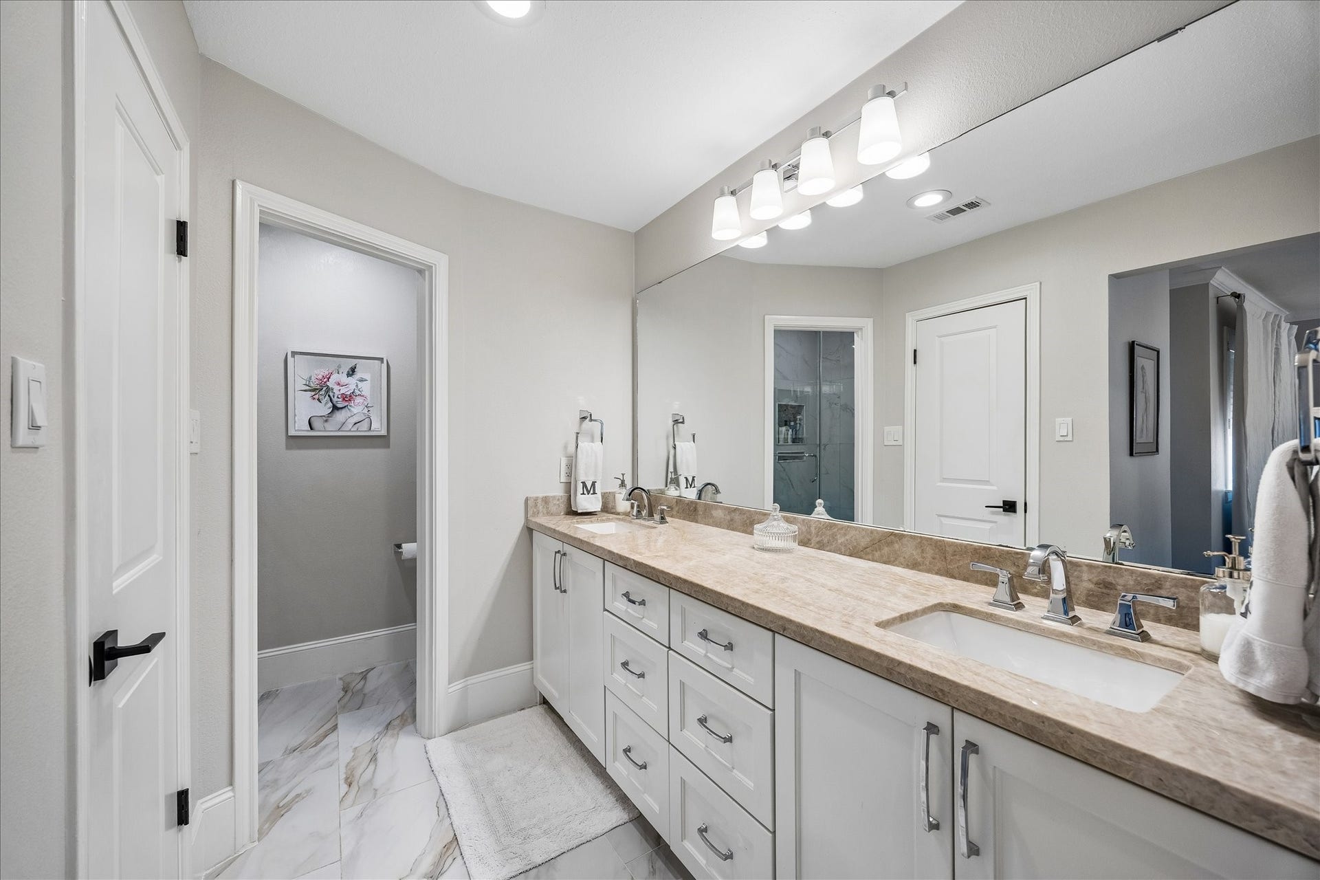 2555 Bering Drive, #11, Houston, TX 77057 Fully remodeled primary bathroom featuring natural quartzite countertops, double sinks, porcelain tile flooring, and upgraded light fixtures.