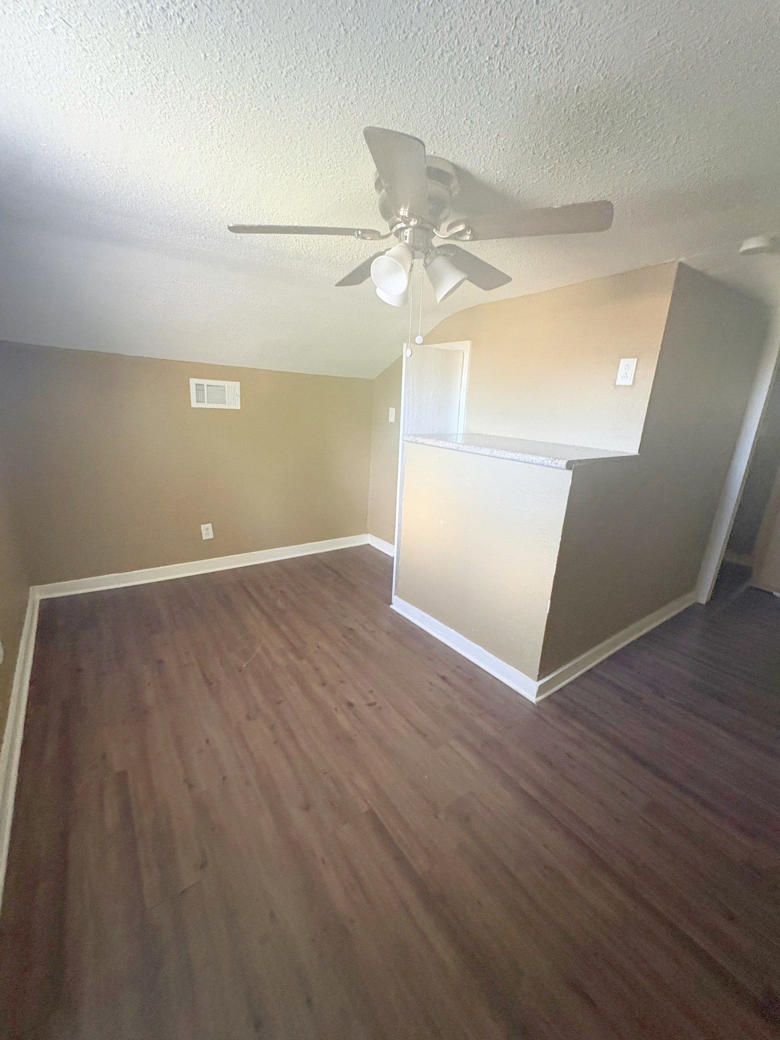 113 N Pecan Drive, Texas City, TX 77591 The upper-level area has wood-look flooring, a ceiling fan, and a half wall by the stairs.