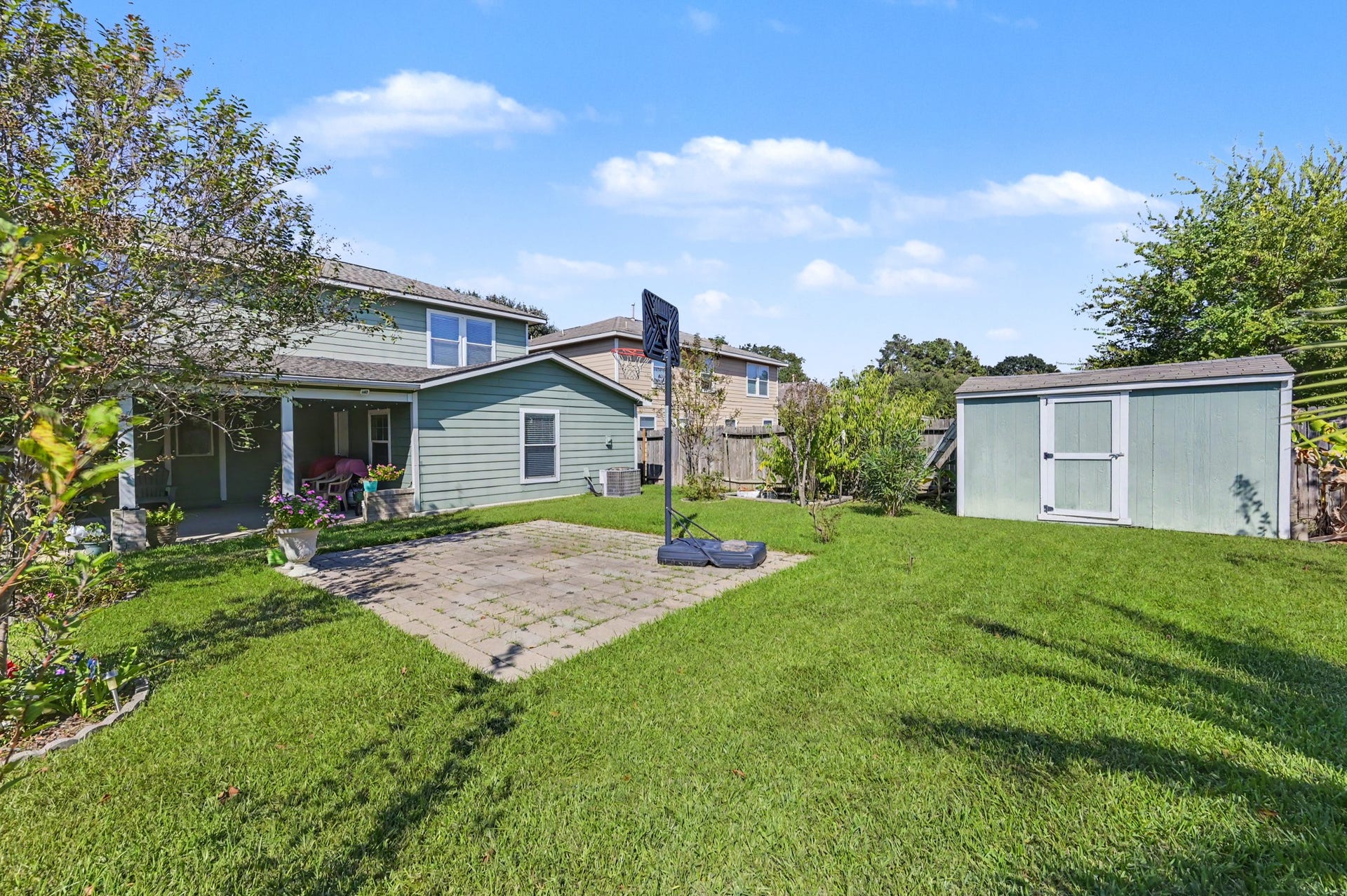 1819 Emerald Pathway Drive, Spring, TX 77388 Spacious backyard featuring a well-maintained lawn, cozy patio area, and a practical storage shed, perfect for outdoor activities and relaxation.