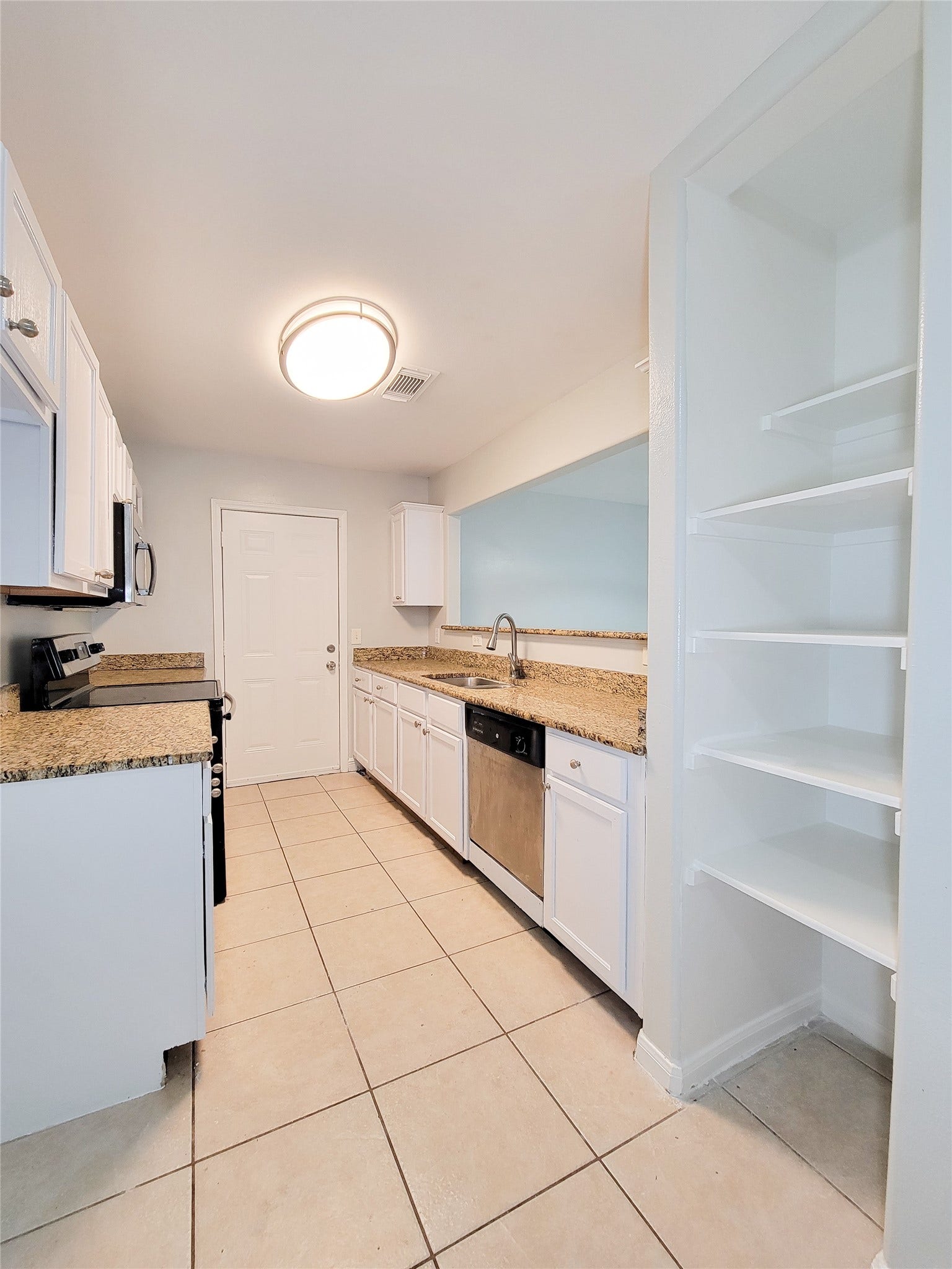 3005 La Estancia Lane, Houston, TX 77093 Bright kitchen featuring granite countertops, stainless steel appliances, and ample storage with open shelving and white cabinetry.
