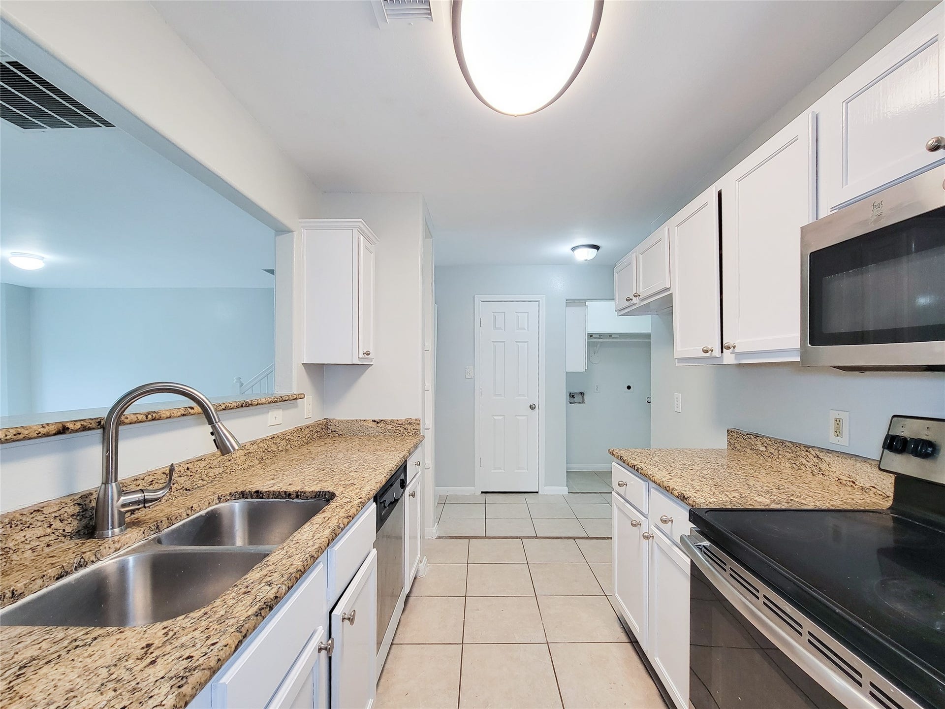 3005 La Estancia Lane, Houston, TX 77093 Bright and modern kitchen featuring granite countertops, stainless steel appliances, and ample cabinet space, seamlessly connected to the living area.