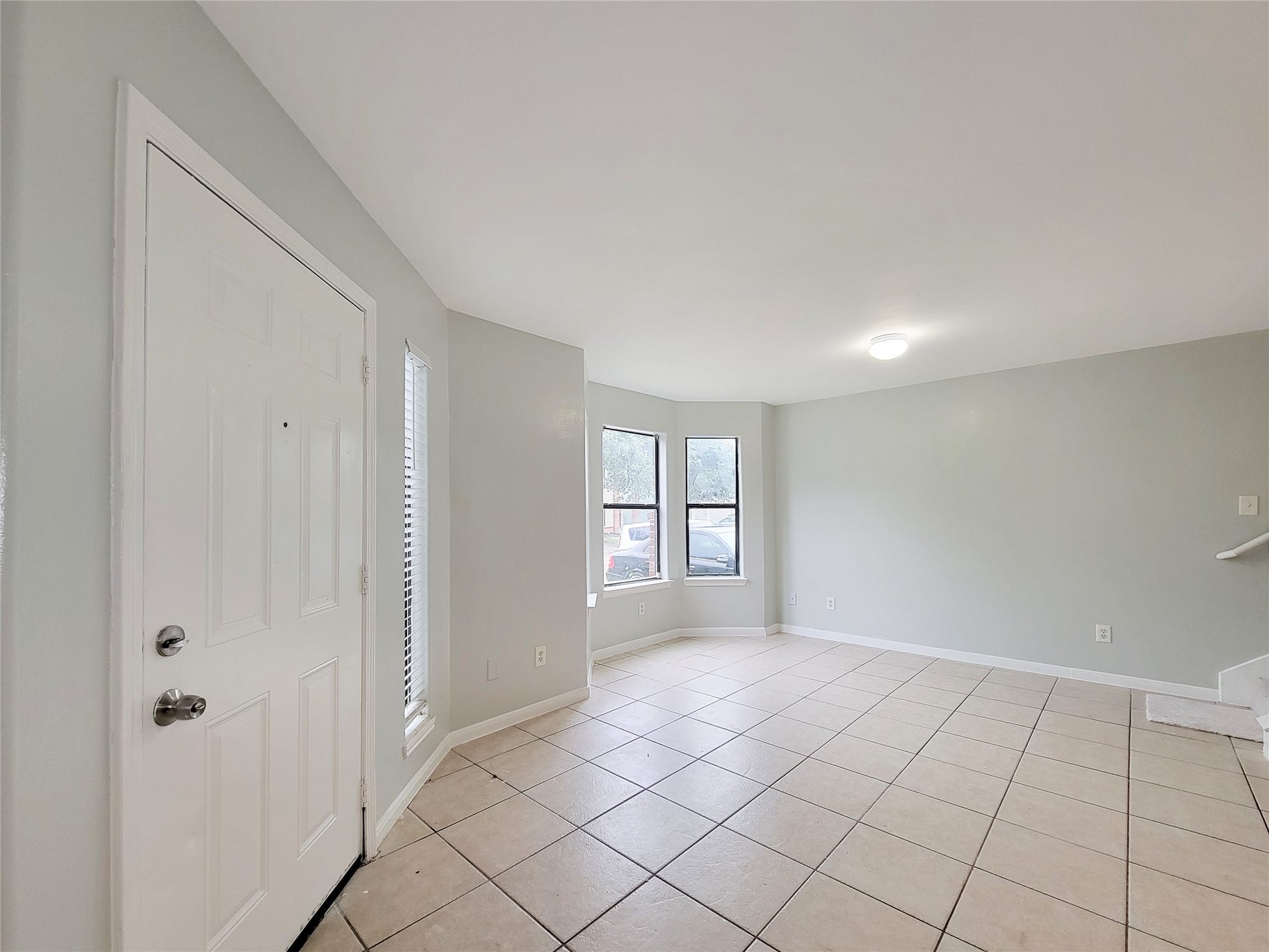 3005 La Estancia Lane, Houston, TX 77093 Bright and spacious entryway with tiled flooring, neutral walls, and ample natural light from large windows, creating an inviting atmosphere.