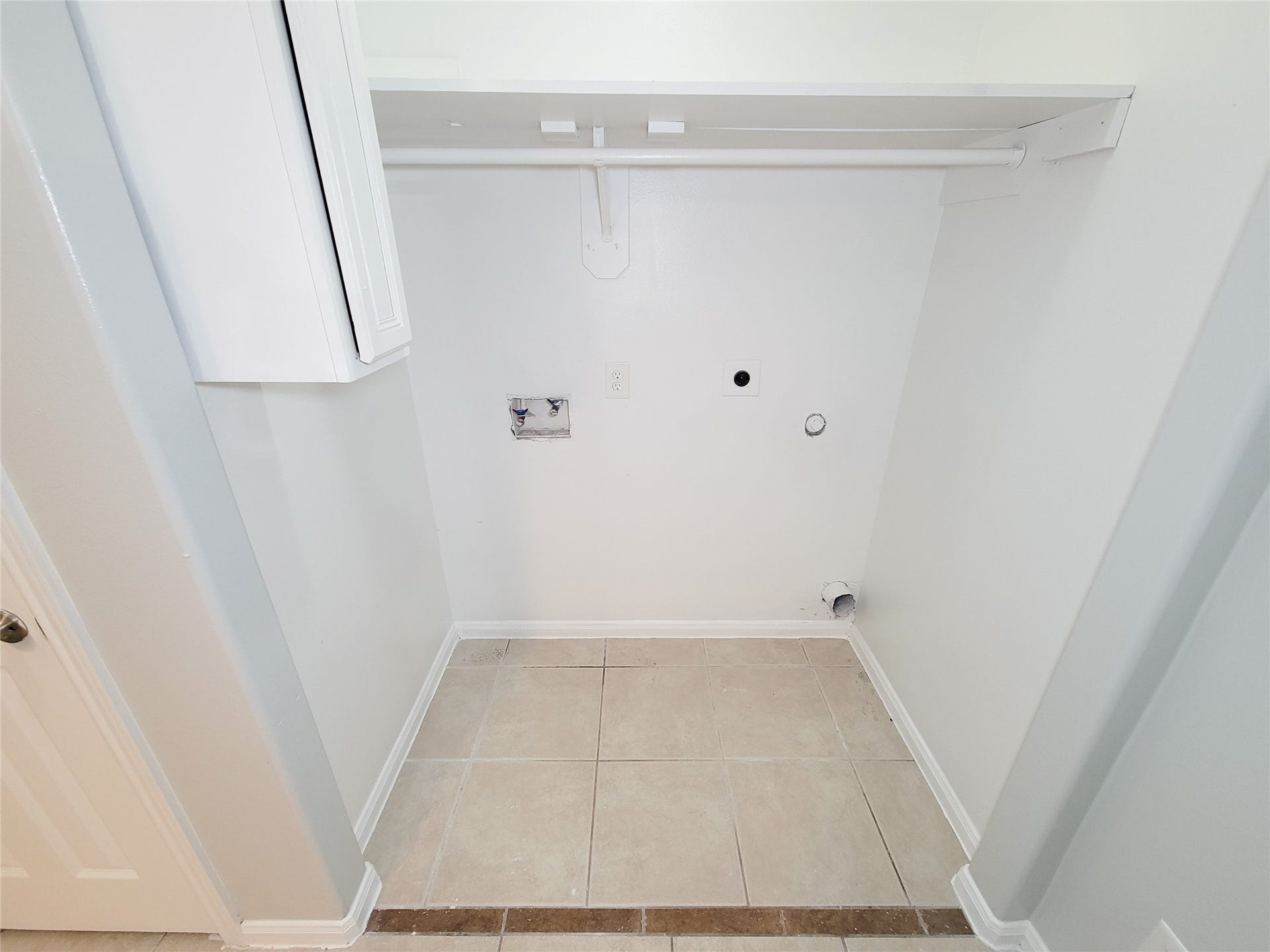 3005 La Estancia Lane, Houston, TX 77093 Spacious laundry area with hookups, featuring a convenient overhead shelf and tile flooring.