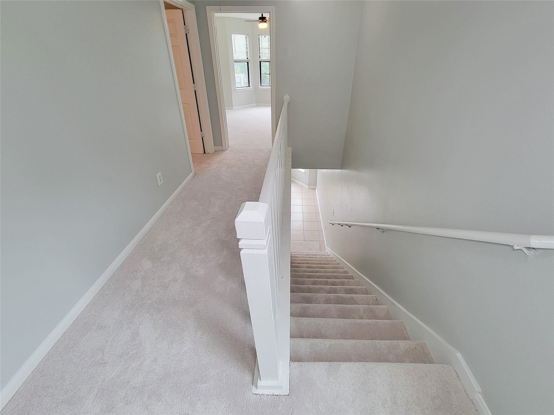 3005 La Estancia Lane, Houston, TX 77093 Bright and airy hallway with plush carpeting leads to a spacious room, offering ample natural light through large windows.