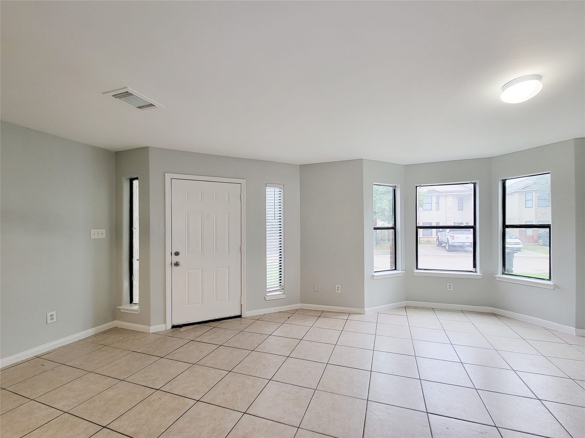 3005 La Estancia Lane, Houston, TX 77093 Bright and airy living space with large windows, neutral walls, and tile flooring create a welcoming environment.