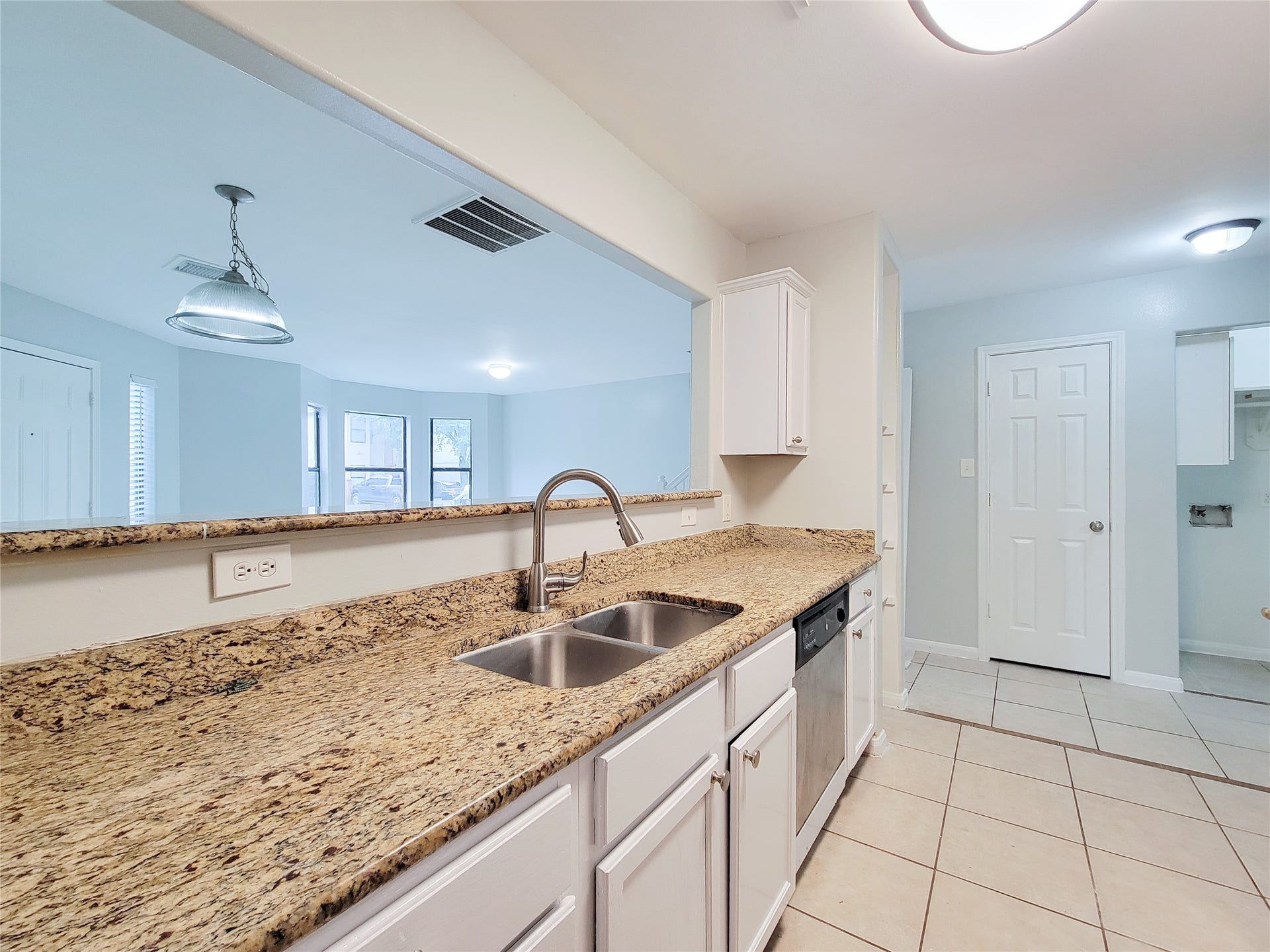 3005 La Estancia Lane, Houston, TX 77093 Spacious kitchen with elegant granite countertops, stainless steel appliances, and an open layout overlooking a bright living area.